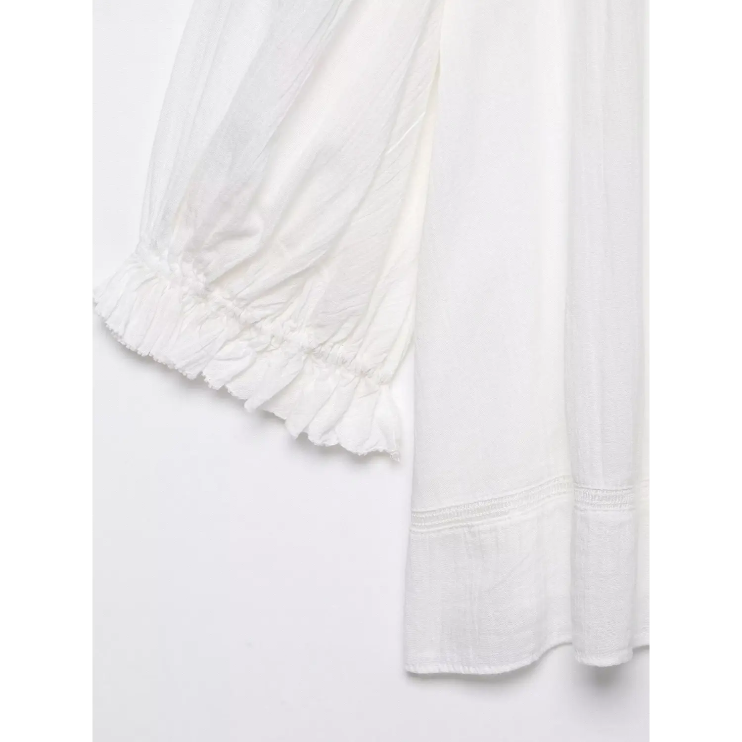 Close-up of elasticated puff sleeve hem, frilled ruffle cuff, lightweight crinkled woven texture