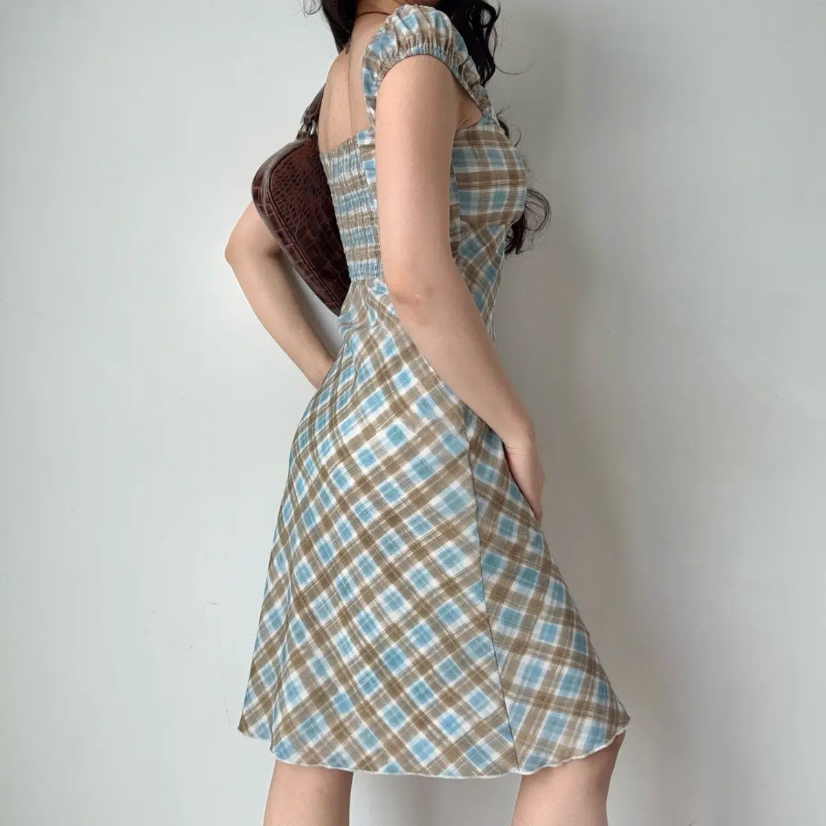 Back view of the blue and brown plaid midi dress, showing the smocked panel.