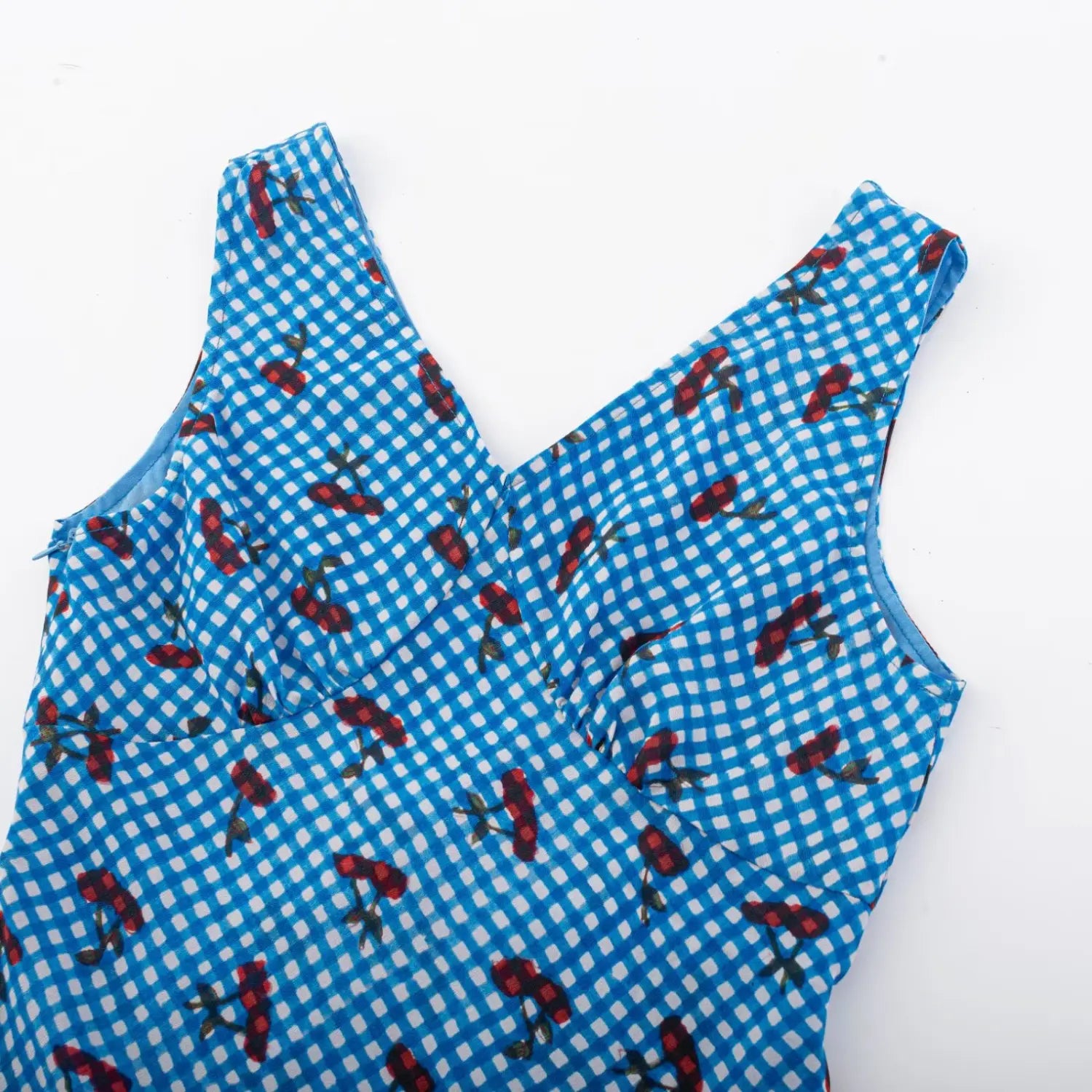 Blue gingham cherry print sleeveless mini dress upper flat shot, deep V cross bust thin shoulder straps check cherry textured fabric bust gathers silhouette detail shot