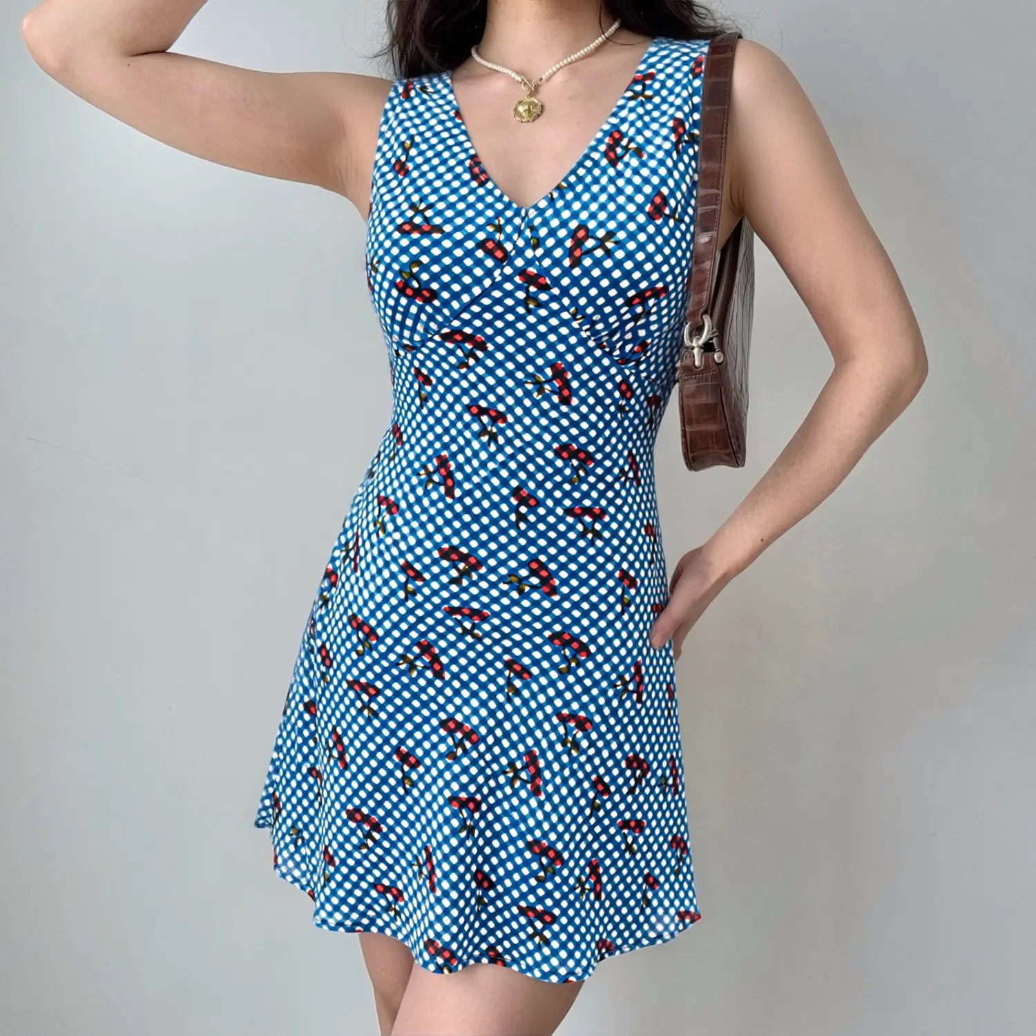 Blue gingham cherry mini dress model daily wearing shot, V-neck flatter collarbone drawstring shape waist A-line swing hem hide hip summer vacation sweet outfit display