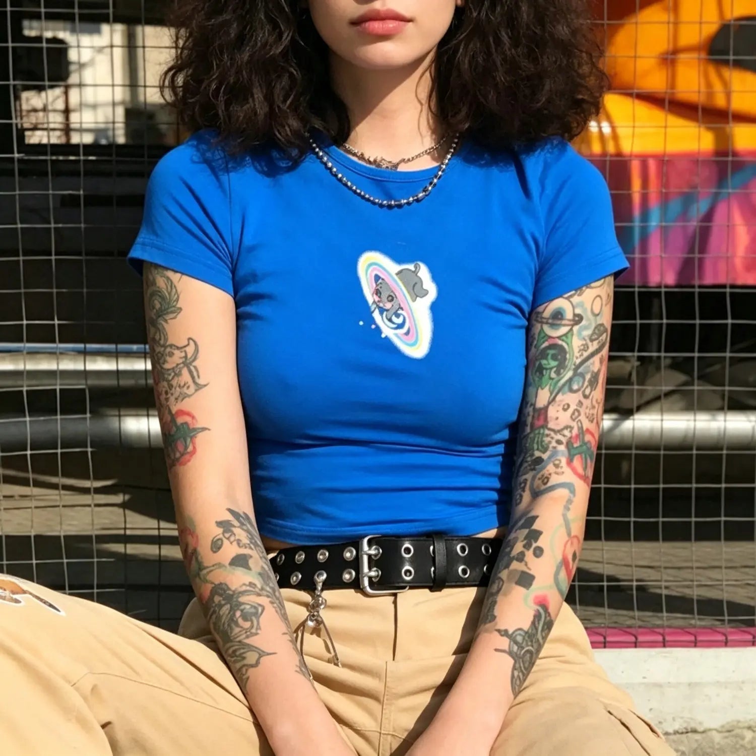 Model wearing vibrant blue slim fit short sleeve crop t-shirt with cute cat rainbow planet graphic print