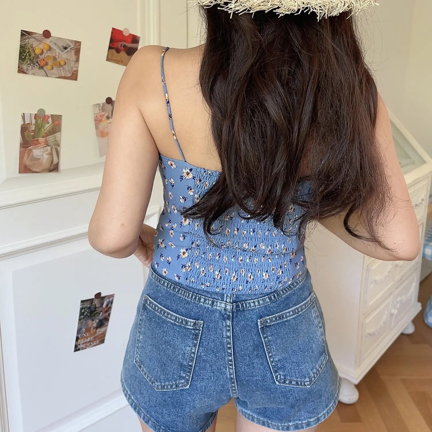 Haze blue daisy cami top back view model shot, full elastic smocked waist matching printed thin straps paired with denim shorts indoor back outfit photo