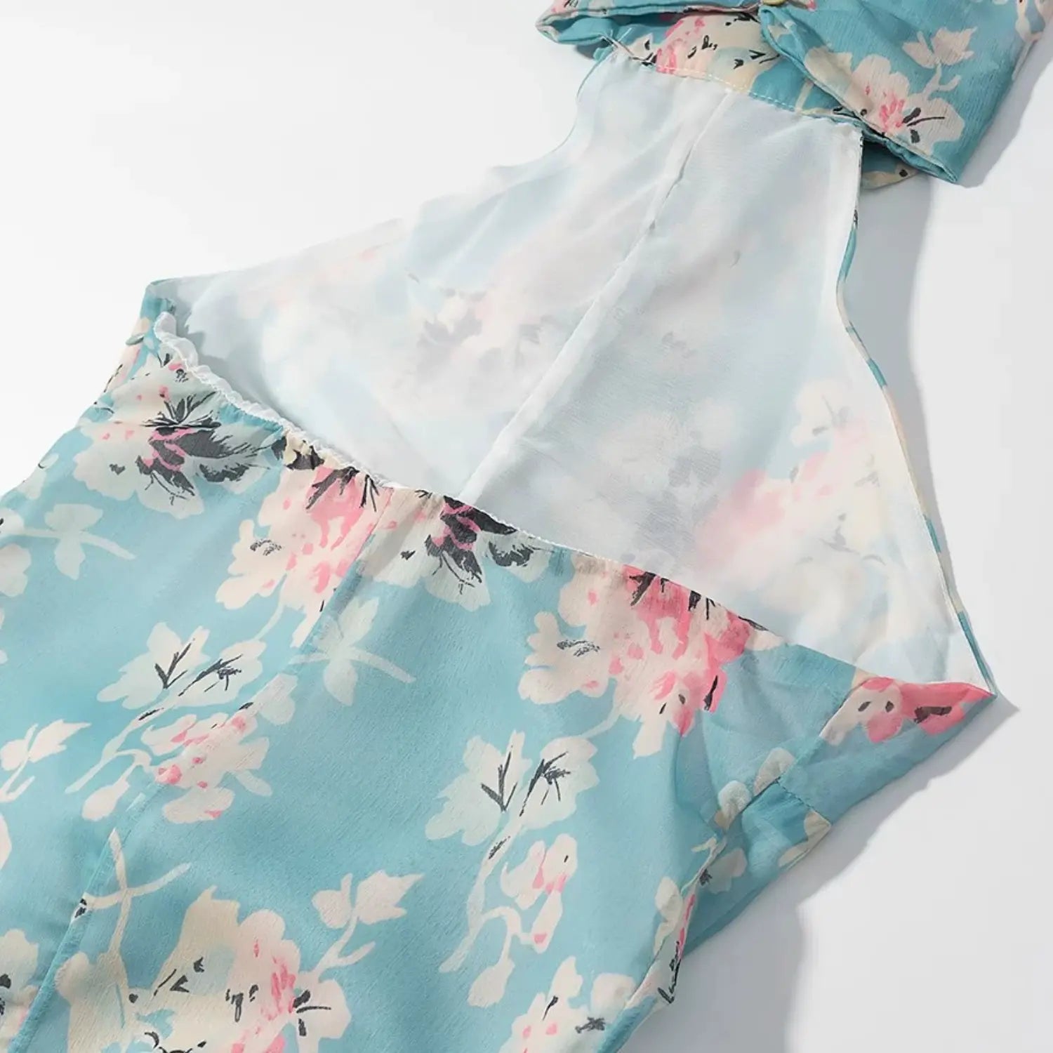 Partial shot of open halter back, white inner lining and full floral print outer chiffon