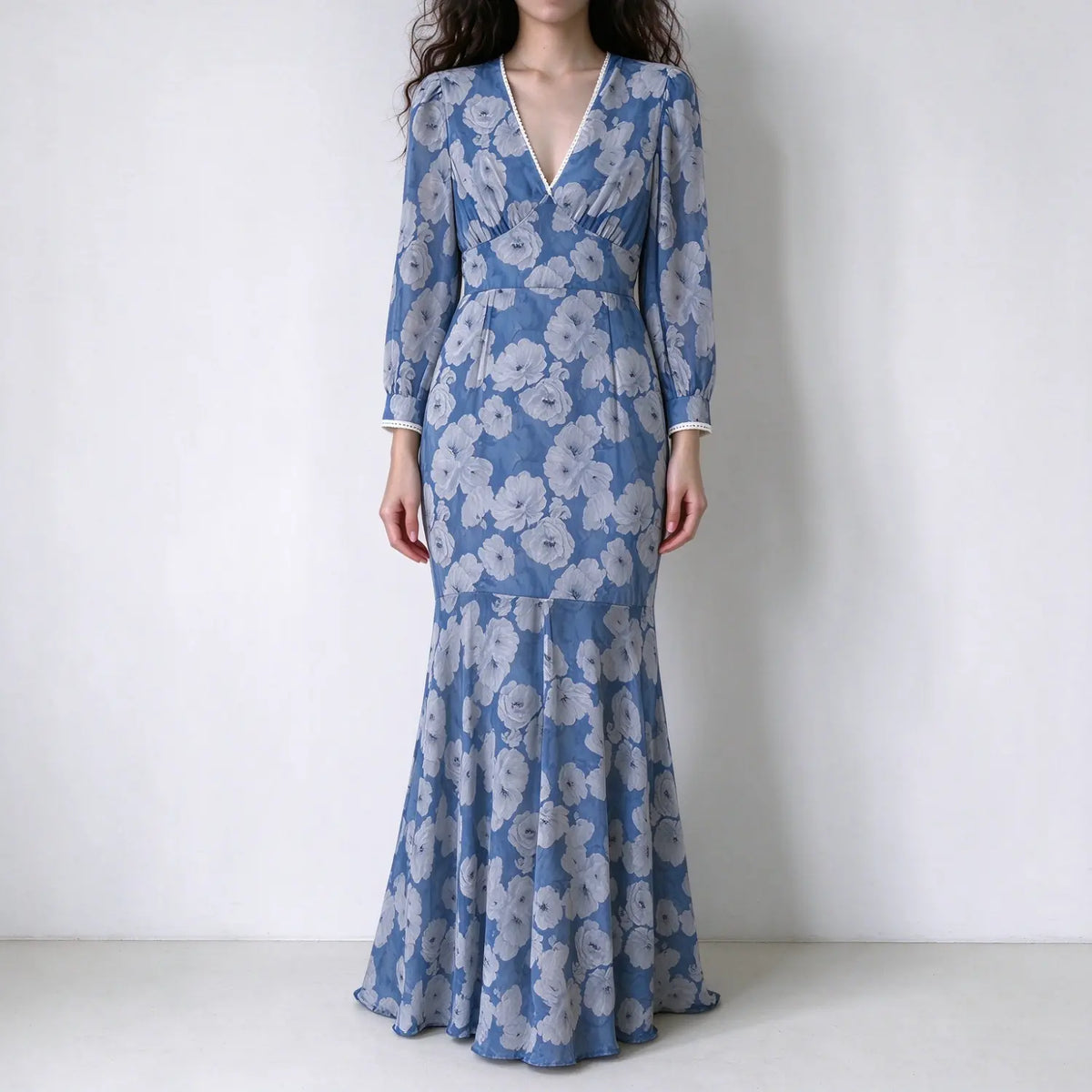 Model wearing blue floral long sleeve maxi mermaid dress, v neck, pearl trim, puff sleeves, fitted flared mermaid hem