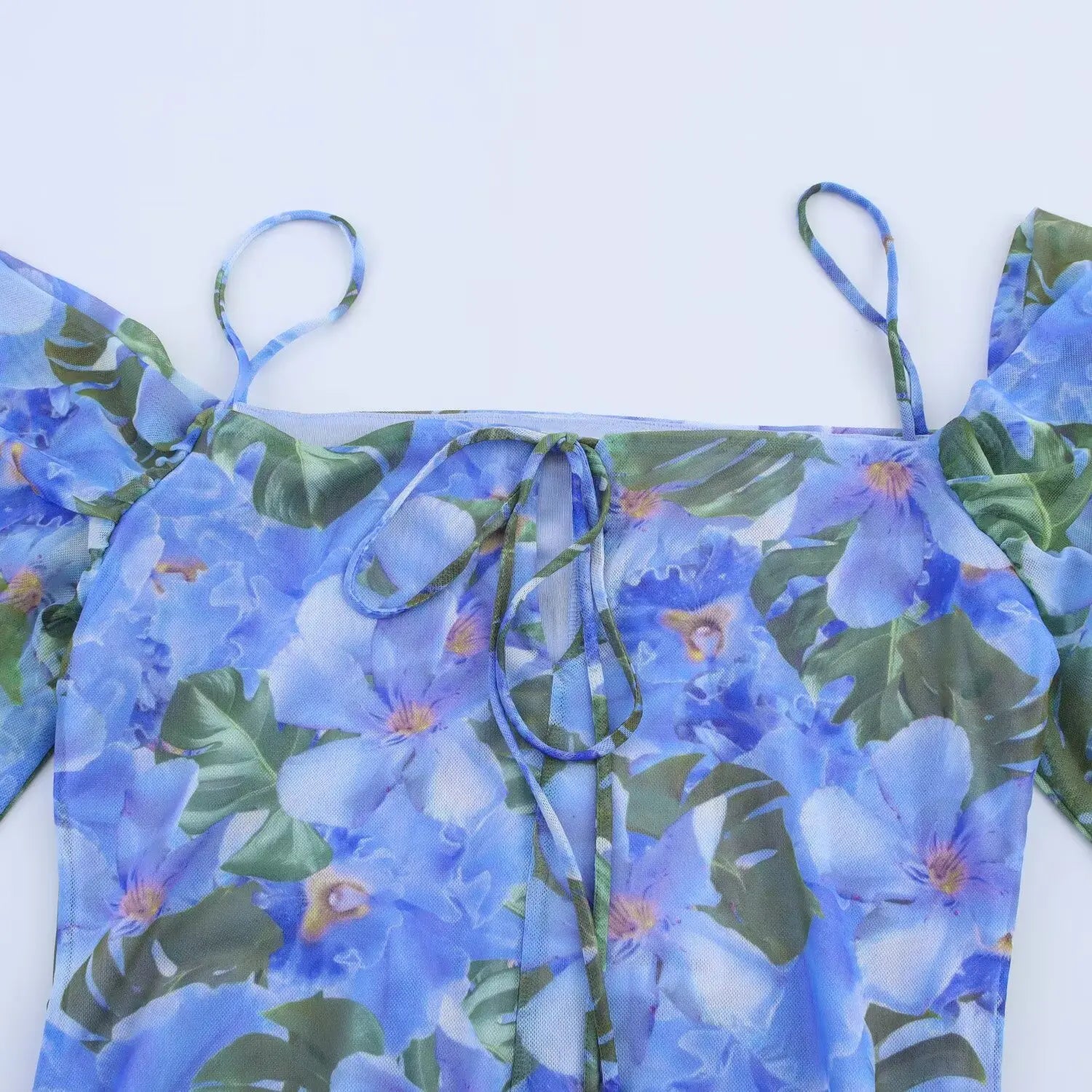 Close‑up of back tie‑up bodice, off‑shoulder design on blue tropical floral mesh mini dress
