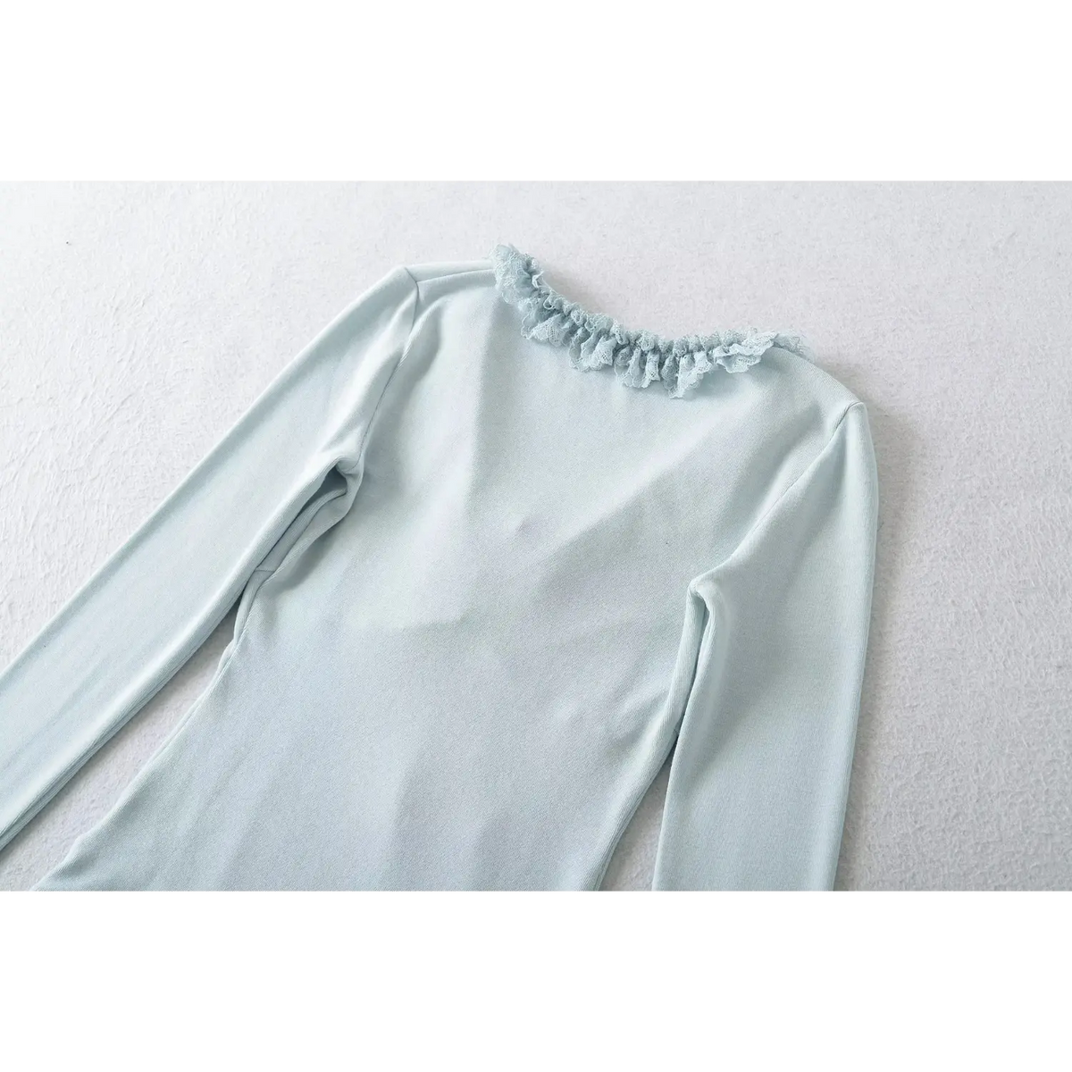 Back view of blue women long sleeve top, lace ruffle along back neckline