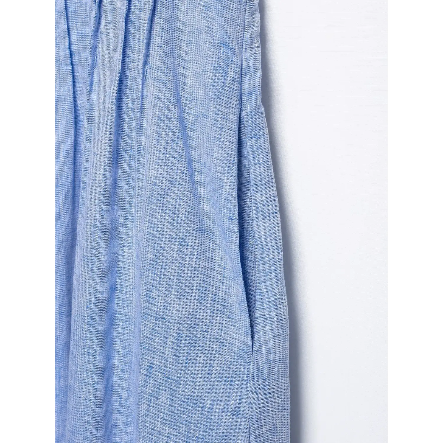 Close‑up side seam pocket detail of blue linen sleeveless maxi dress, textured woven linen fabric