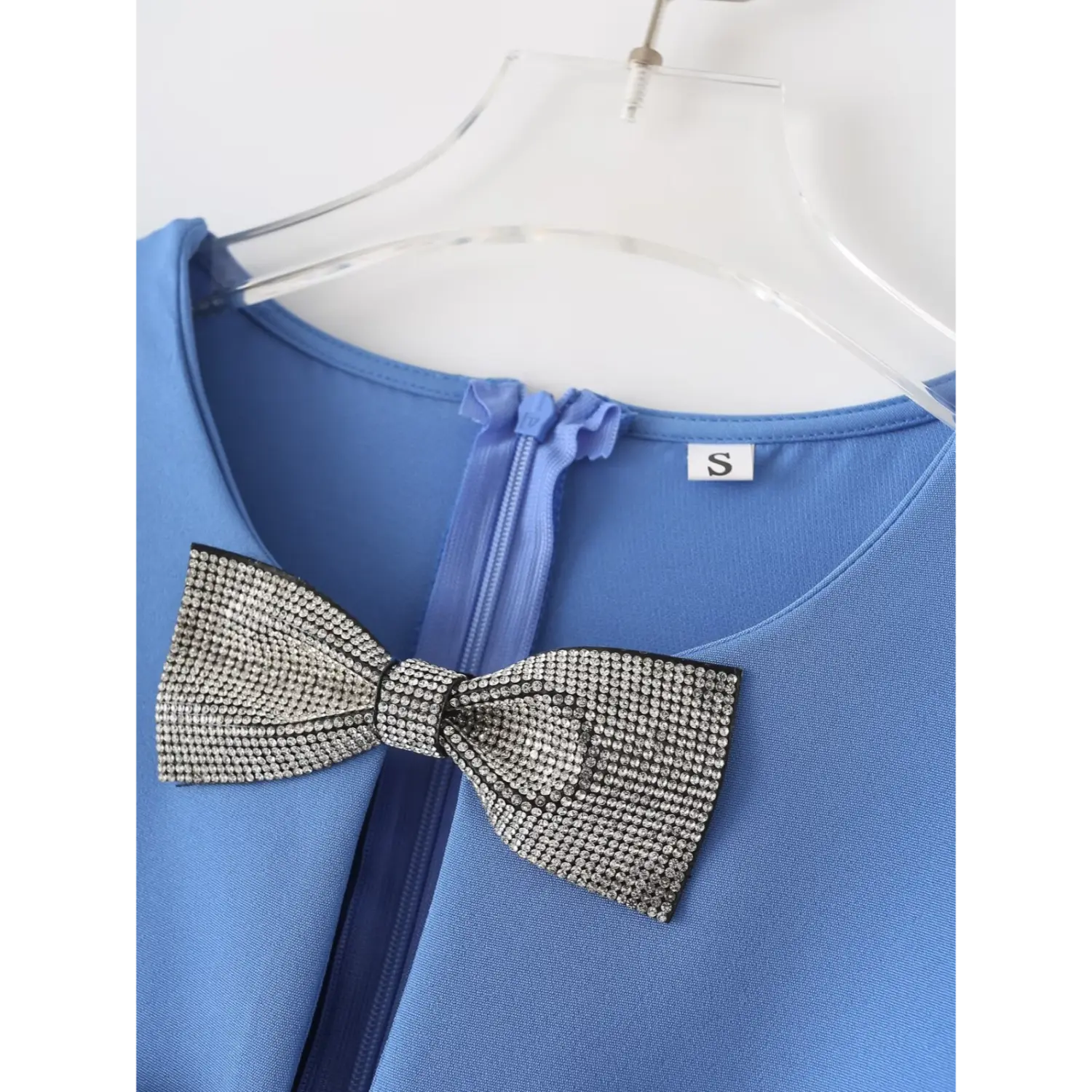 Macro close‑up sparkling rhinestone bow applique, round neck, inner back zipper and clothing size tag