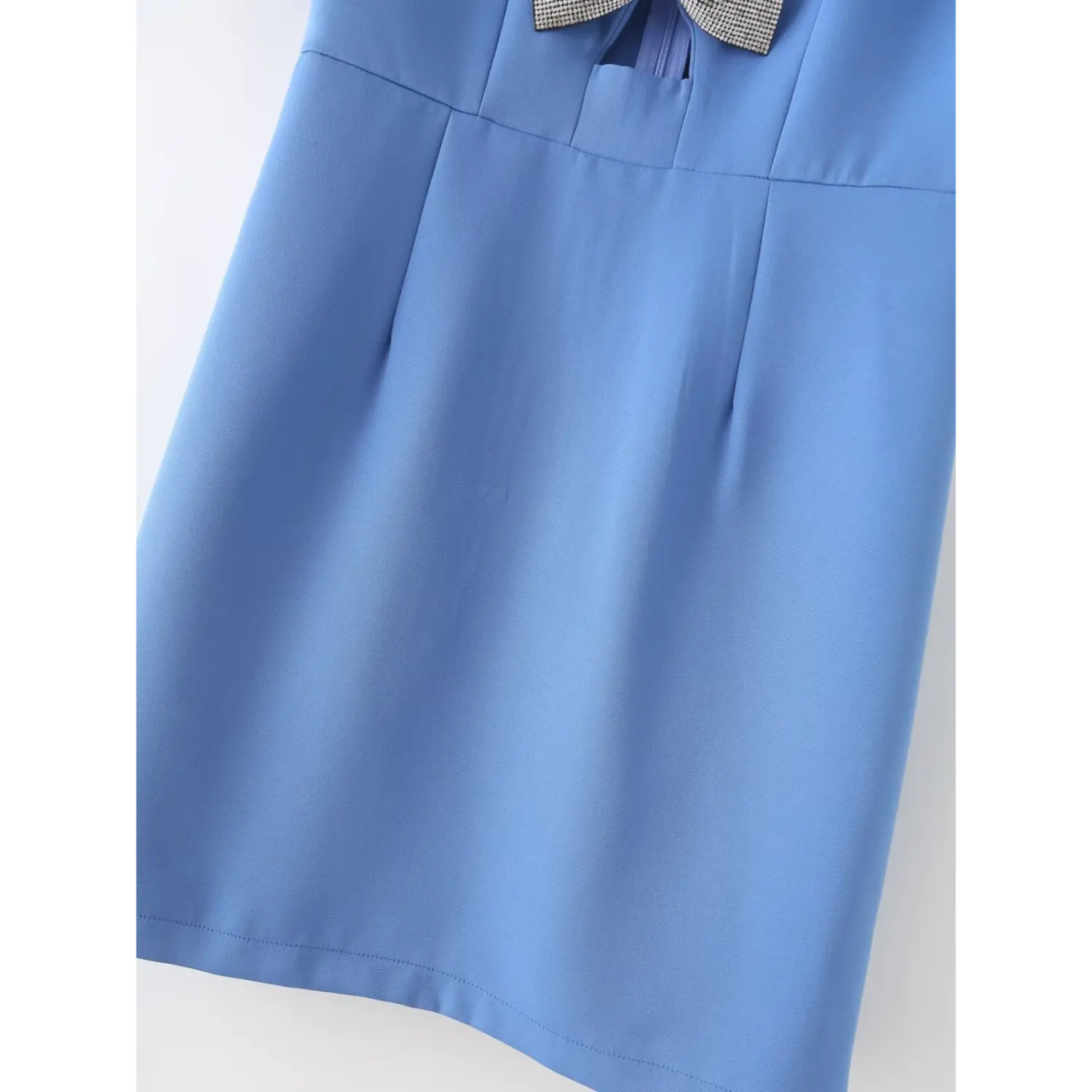 Close‑up of skirt dart seams and finished bottom hem, smooth blue fabric of short mini dress