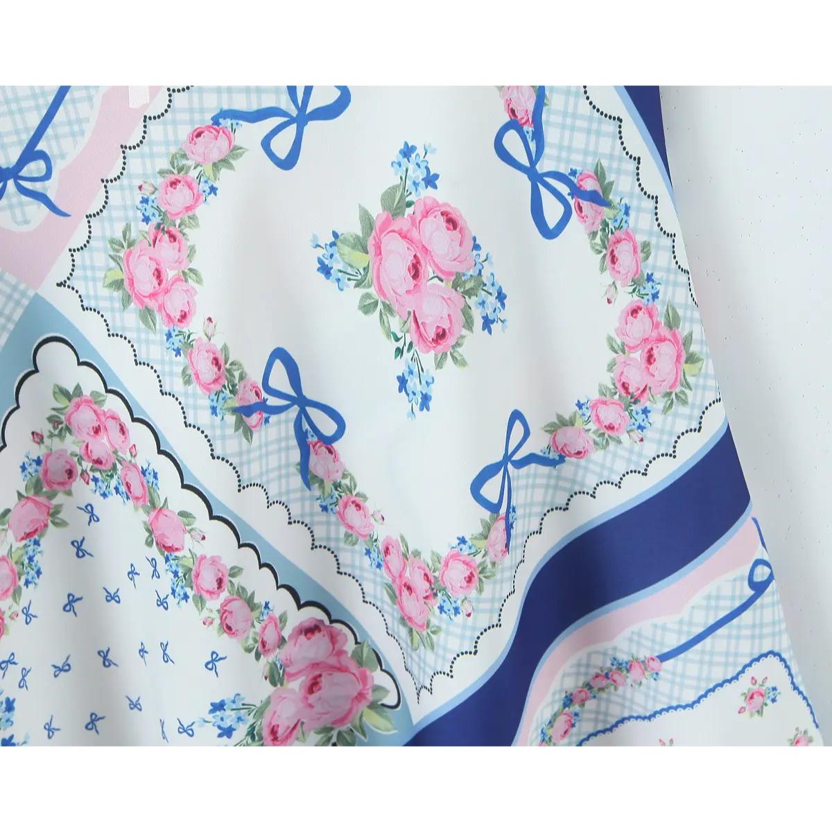 Close-up of the geometric print panels and floral motifs on the dress fabric.