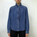 Model wearing blue ruffle collar denim shirt with black slim jeans