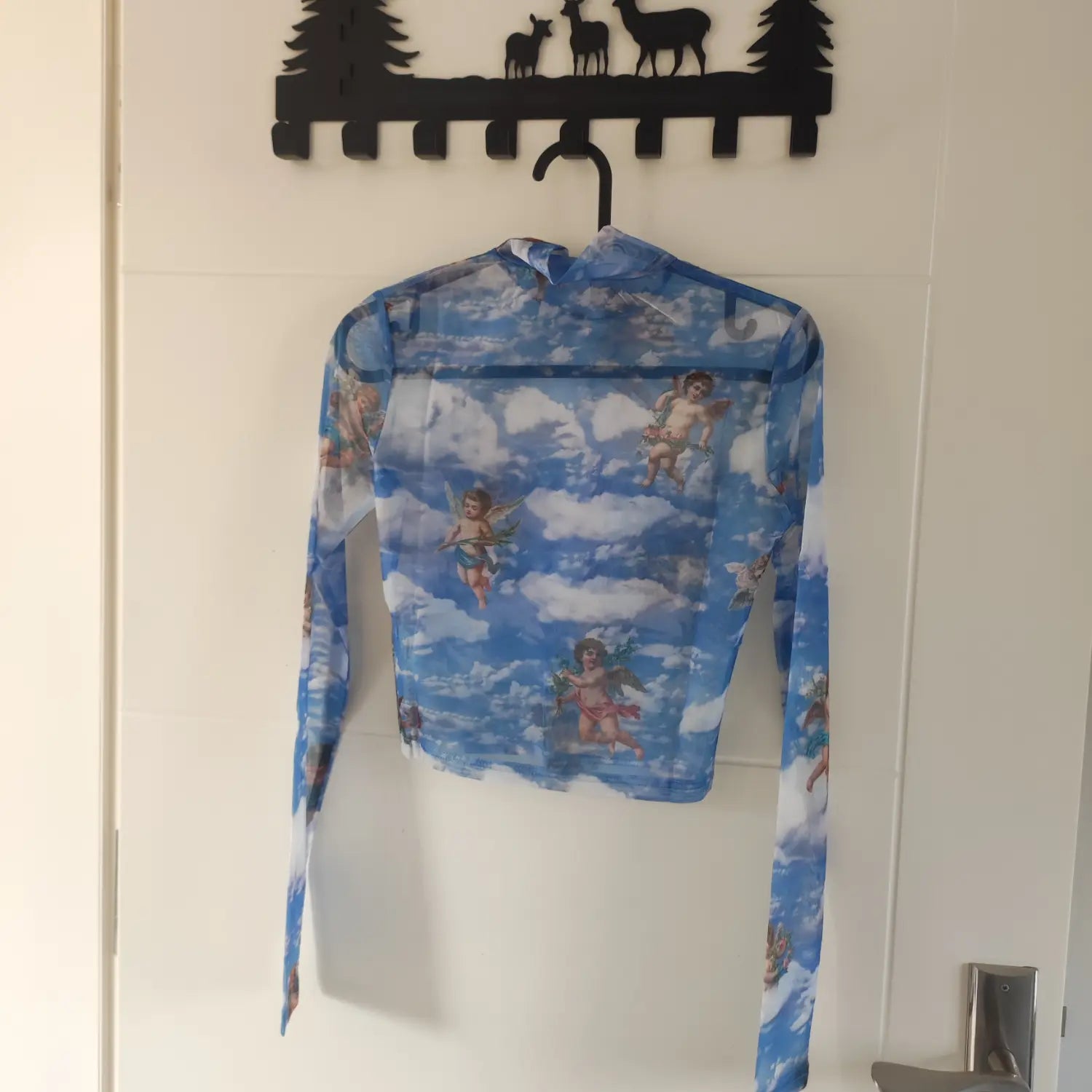 Hanging back view blue sheer mesh cropped high neck top showing full cherub sky print pattern