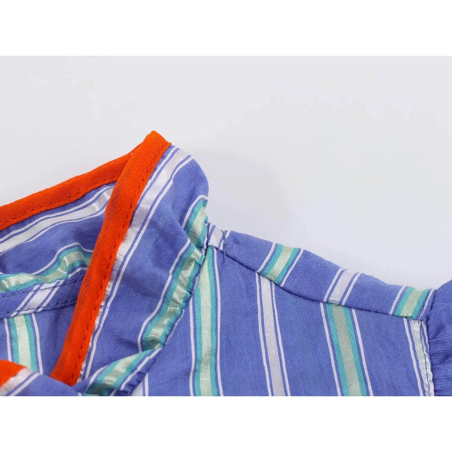 Front stand ruffle collar partial shot, orange contrast piping trim, vertical stripe textured fabric, folded placket seam