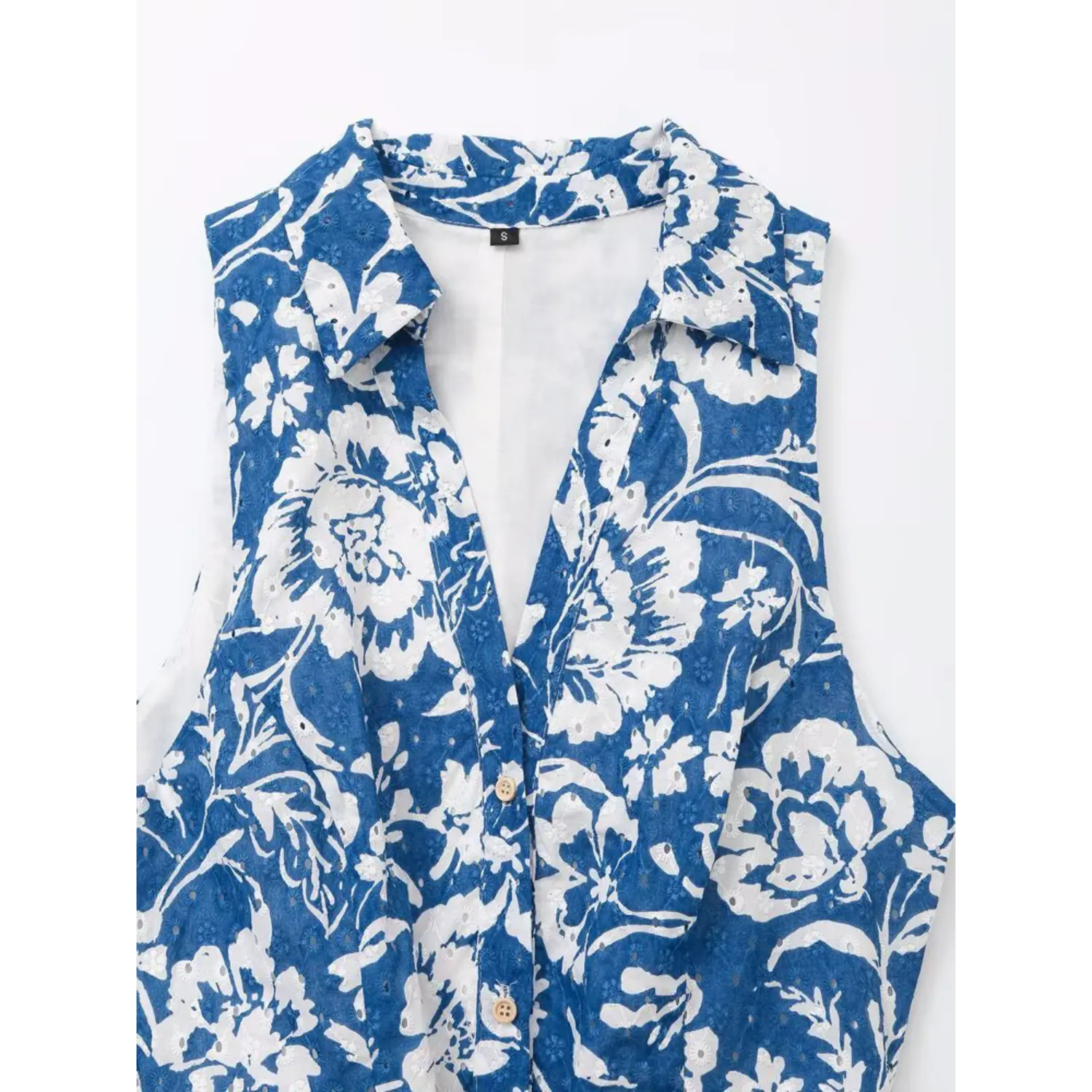 Close-up shot of the shirt collar and button placket on the blue floral sleeveless dress