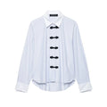 Studio white background full front shot of blue white vertical stripe long sleeve shirt, contrast white collar & cuffs, front black chinese frog knot buttons, curved hem relaxed fit