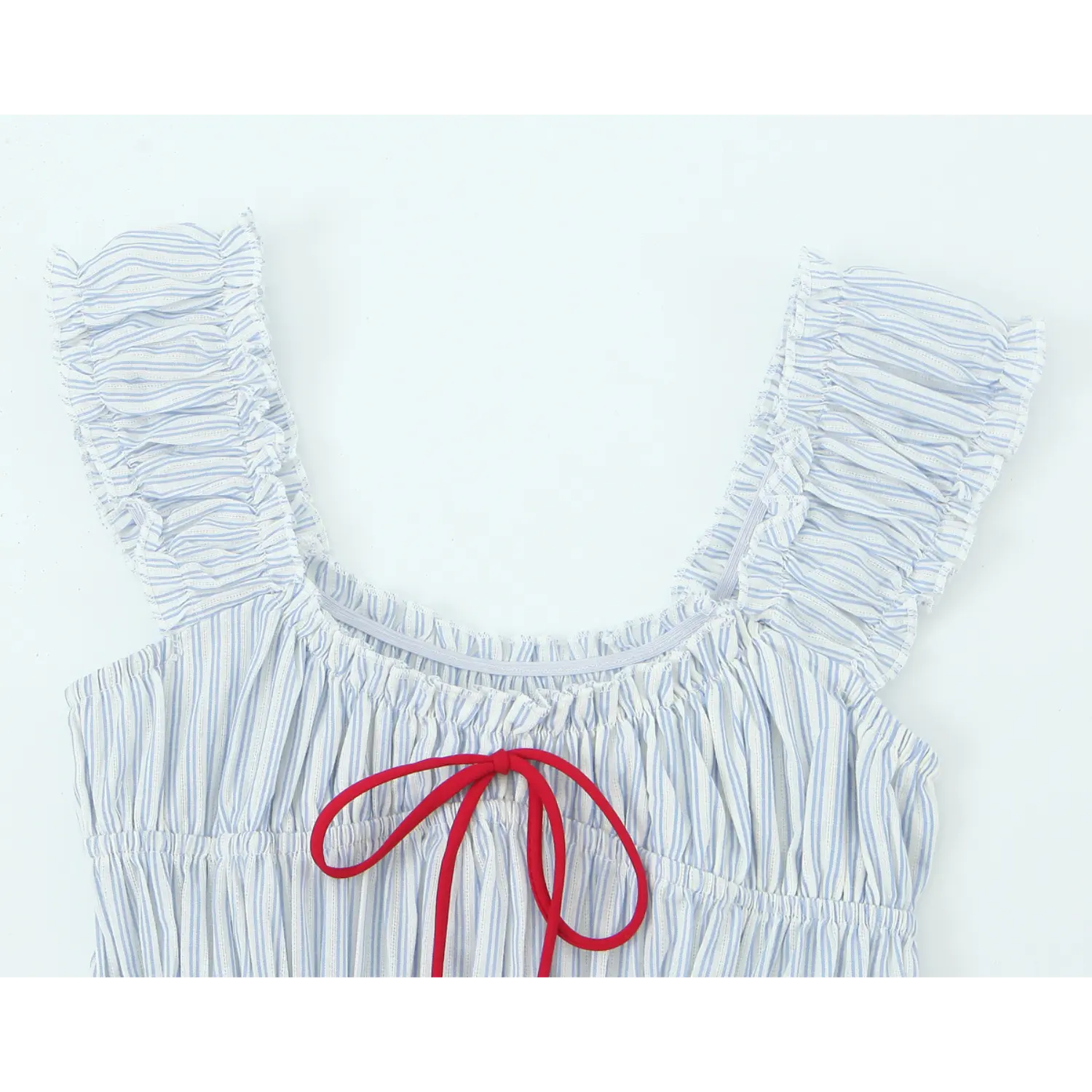 Close‑up of square neckline with ruffle shoulder straps and bright red fabric bow tie on blue white striped smocked dress