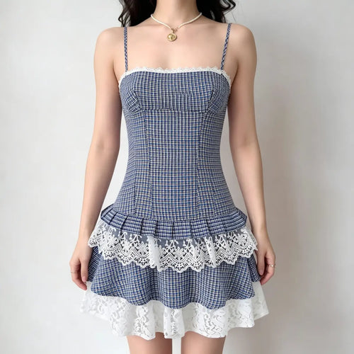 Model wearing a blue and yellow plaid camisole dress with layered lace trim at the neckline and hem, and spaghetti straps.