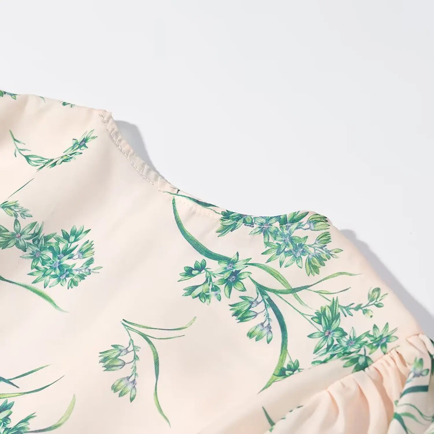 Close‑up texture of back yoke fabric with green botanical floral print