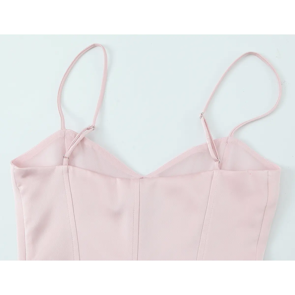Back view of the blush pink bustier top, showing the adjustable spaghetti straps, sweetheart neckline, and structured seams
