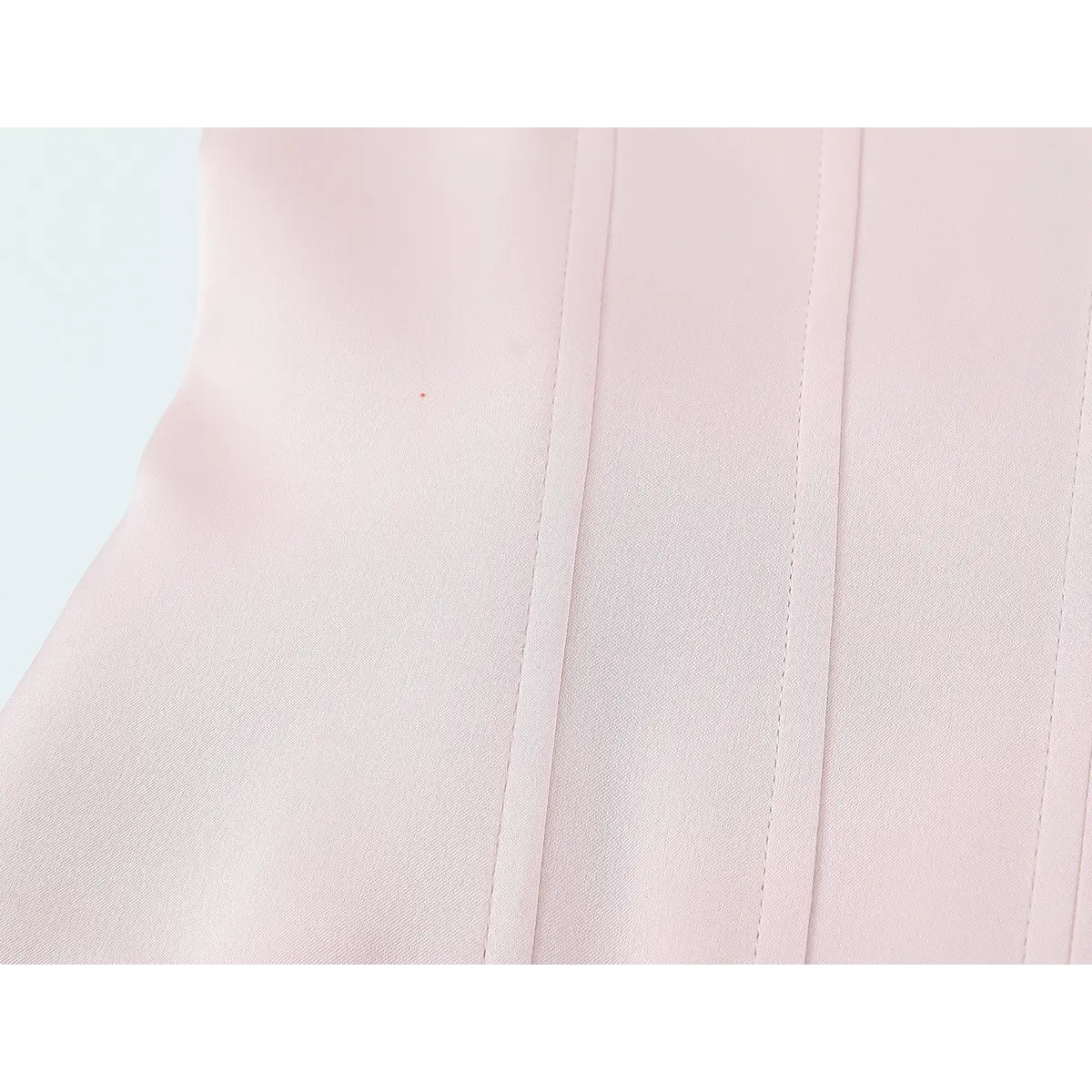 Close-up of the vertical boning seams on the blush pink bustier top, highlighting the clean stitching and fabric texture