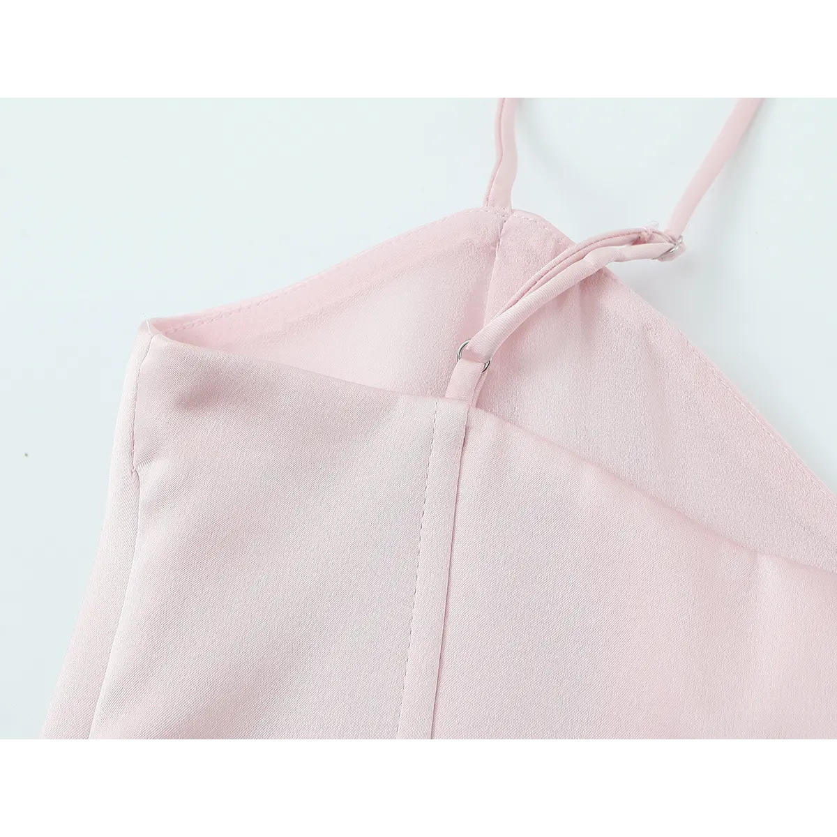 Close-up of the adjustable spaghetti strap on the blush pink bustier top, showing the slider mechanism and inner construction