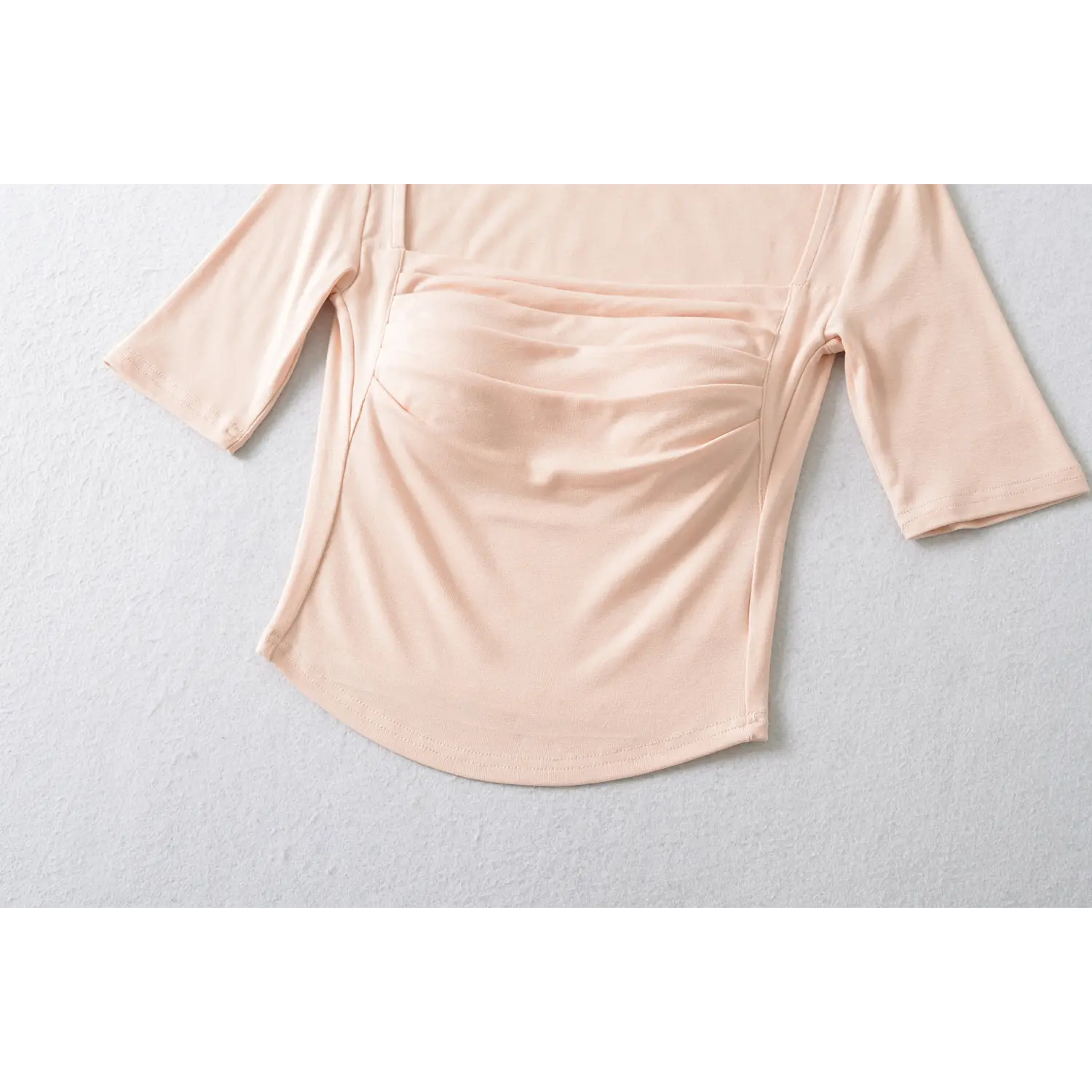Blush pink crop top curved hem and side ruching close up, slim waist shaping stretch jersey women short top