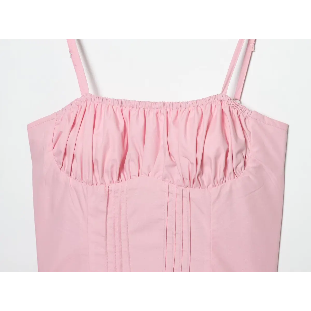 Upper bust close detail, elastic ruched sweetheart bust and vertical corset pintuck stitching on solid pink woven fabric.