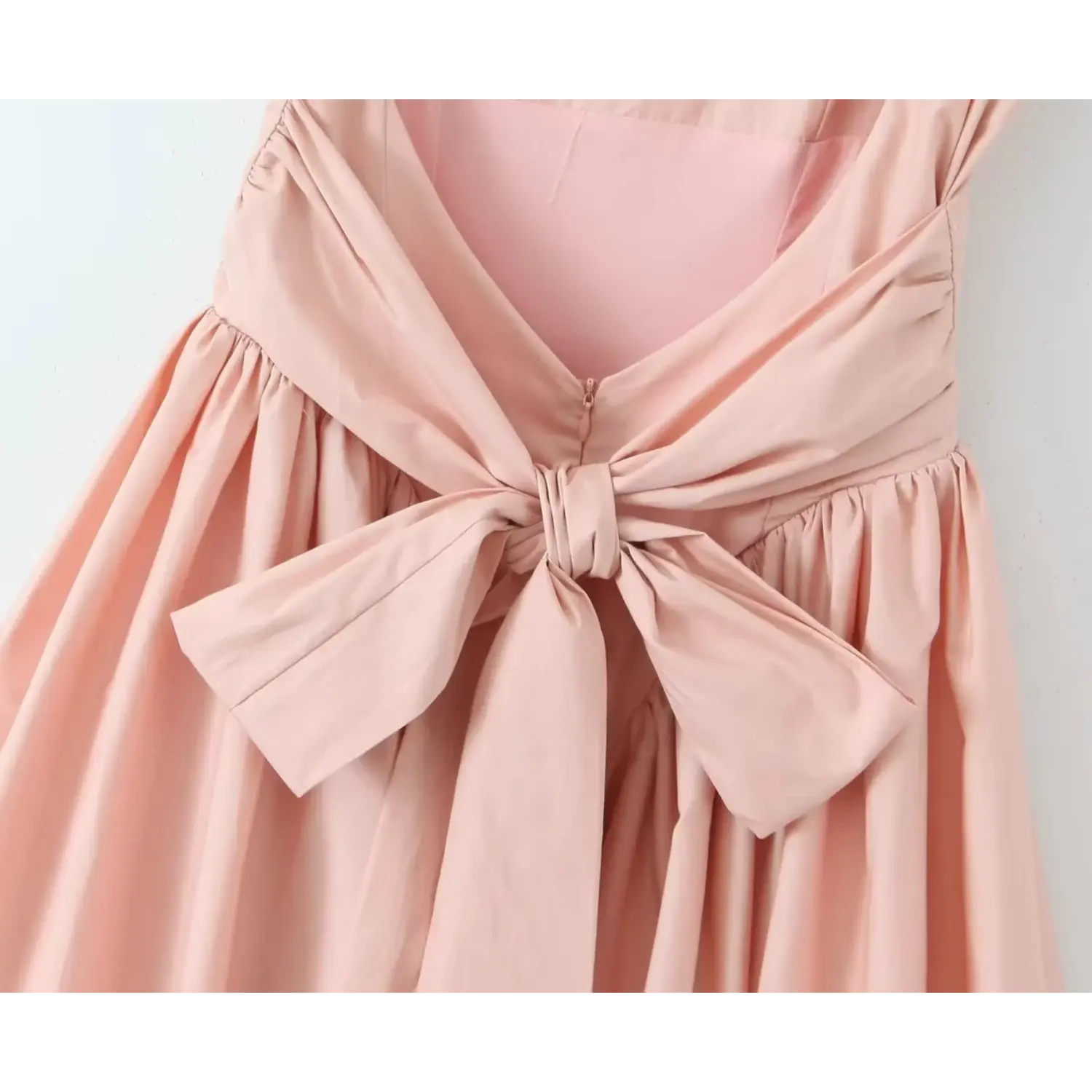 Close‑up back view, big fabric bow knot with long sash tails, open back design, gathered waist and skirt of blush pink mini dress