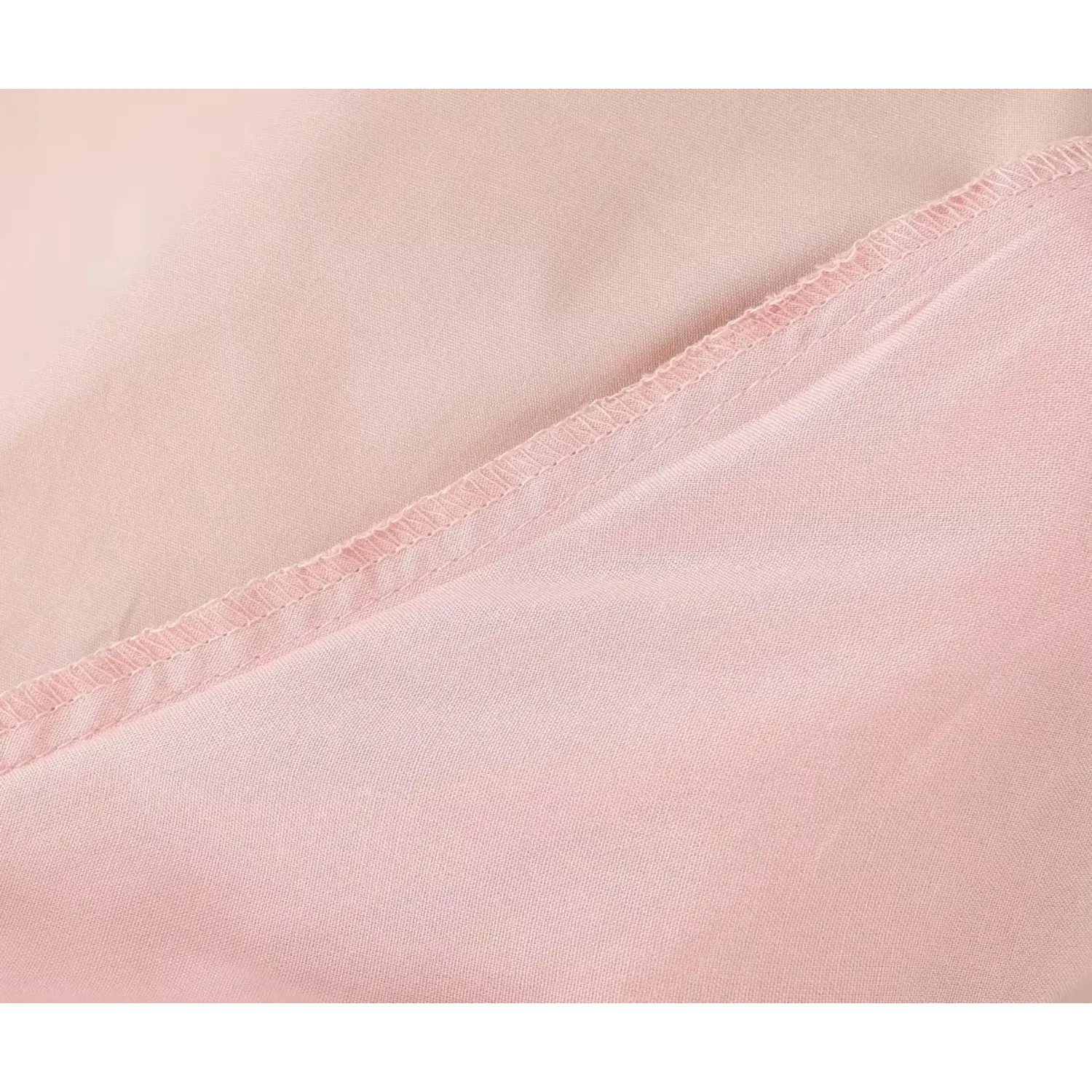 Close‑up of dress inner lining and finished overlock seam, neat stitching detail on soft blush pink fabric