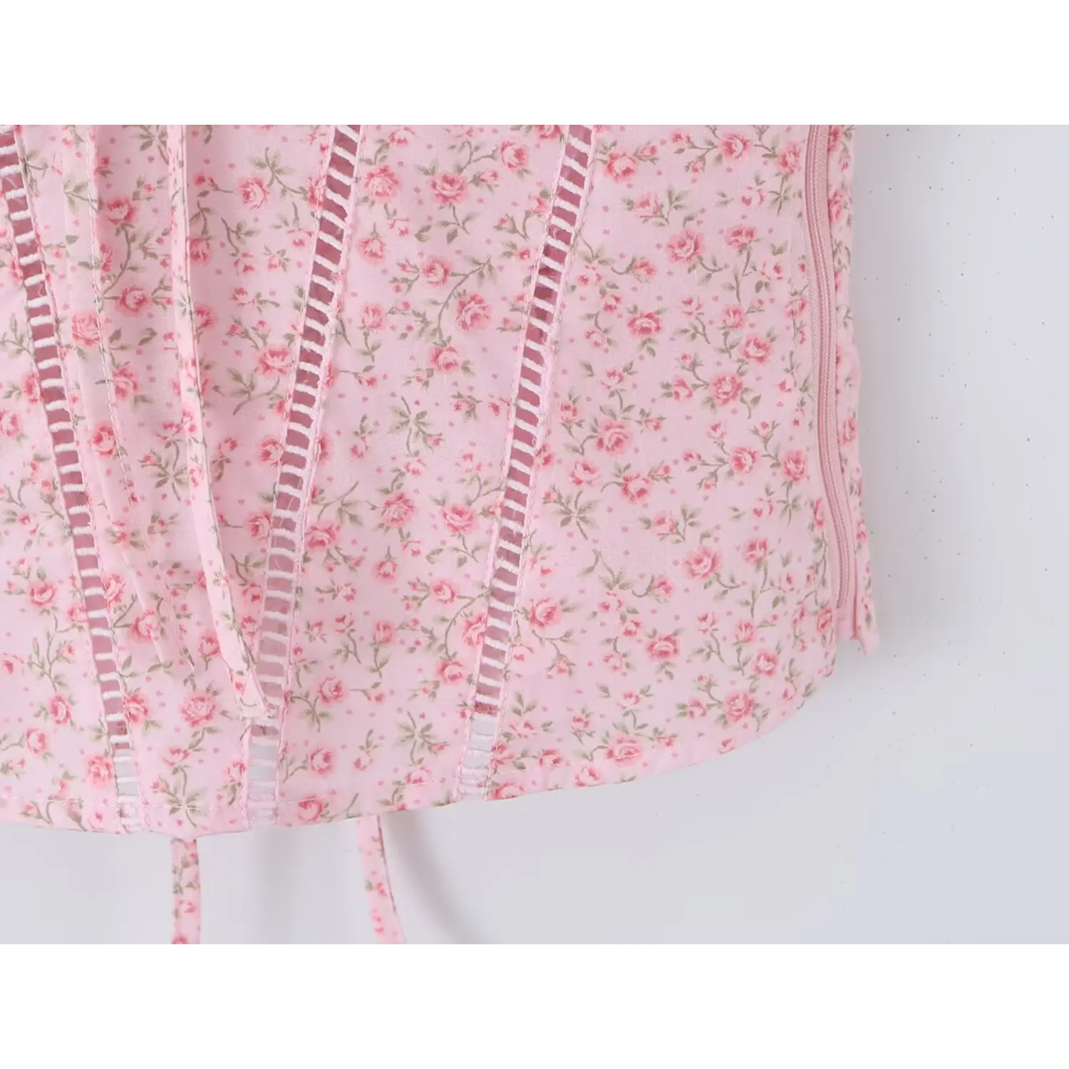 Waist closeup vertical ladder cutout eyelet seams, corset shaping panels, pink floral woven fabric