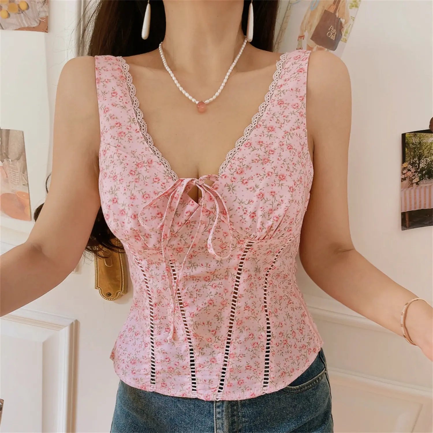 Women lifestyle photo blush pink ditsy rose print corset tank, sleeveless lace edged straps, front drawstring tie, waist shaping cutout stitching