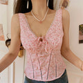Close front model shot blush pink rose ditsy print corset camisole, bust tie detail, vertical ladder cutout seams, scalloped lace neck trim