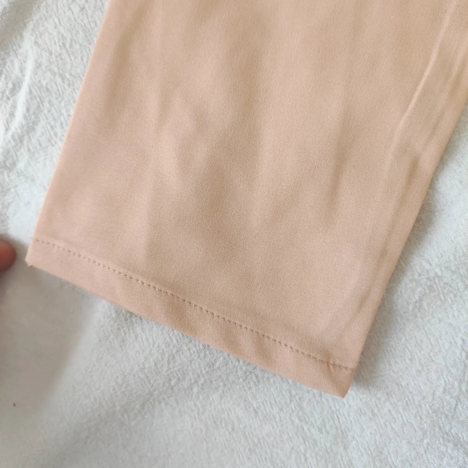 sleeve-hem-detail-view | Close view sleeve hem stitching of blush pink long sleeve cropped blouse