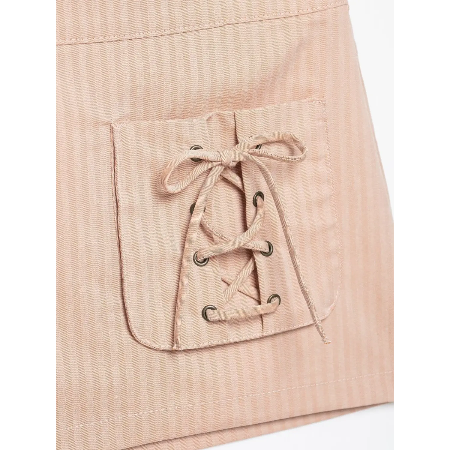 Macro close‑up pocket bow tie and metal eyelet craftsmanship blush pink striped mini skirt