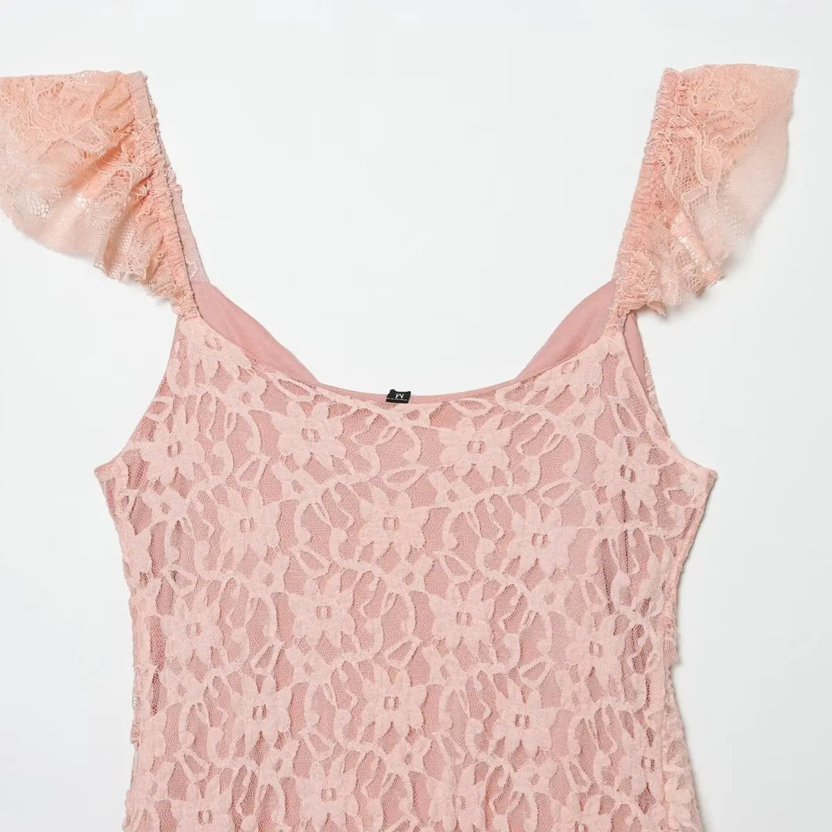 Close-up of the back scoop neckline on the blush pink lace dress, showing the floral lace pattern and ruffled straps