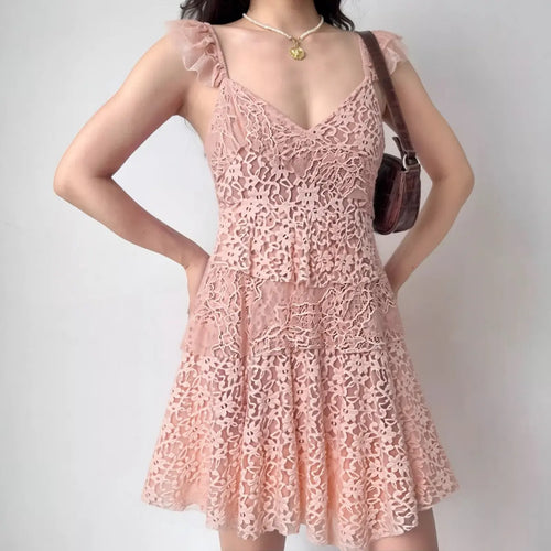 The blush pink tiered lace dress worn by a model, showing the V-neckline, ruffled straps, and full skirt silhouette
