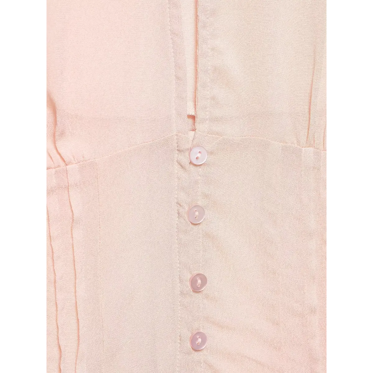 Close-up of the matching pink shell buttons on the front placket.
