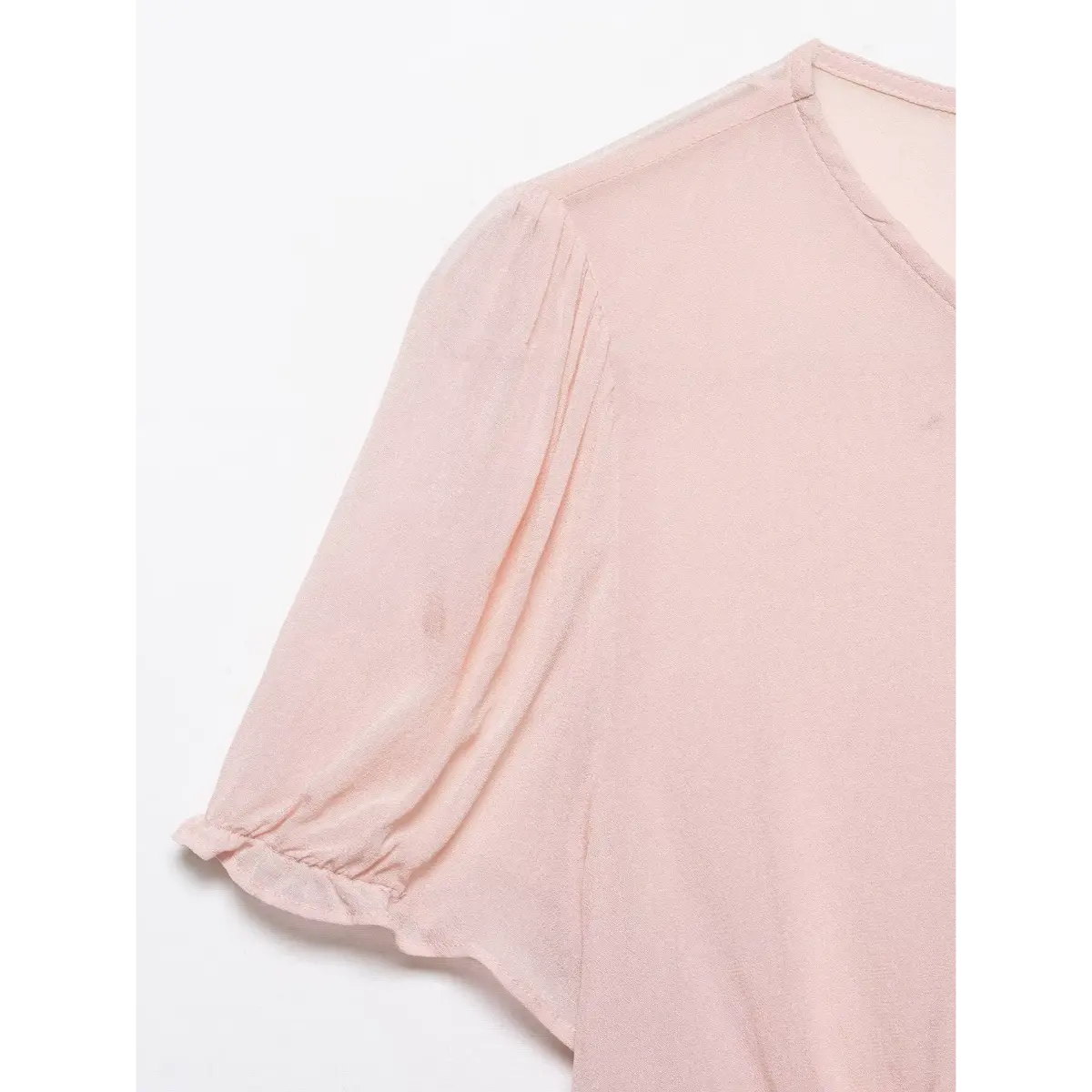 Close-up of the puff sleeve and gathered cuff on the blush pink blouse.