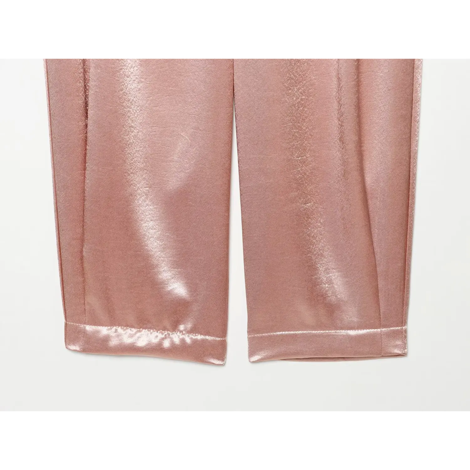 Partial flat view cropped cuffed hem and leg silhouette of blush satin trousers