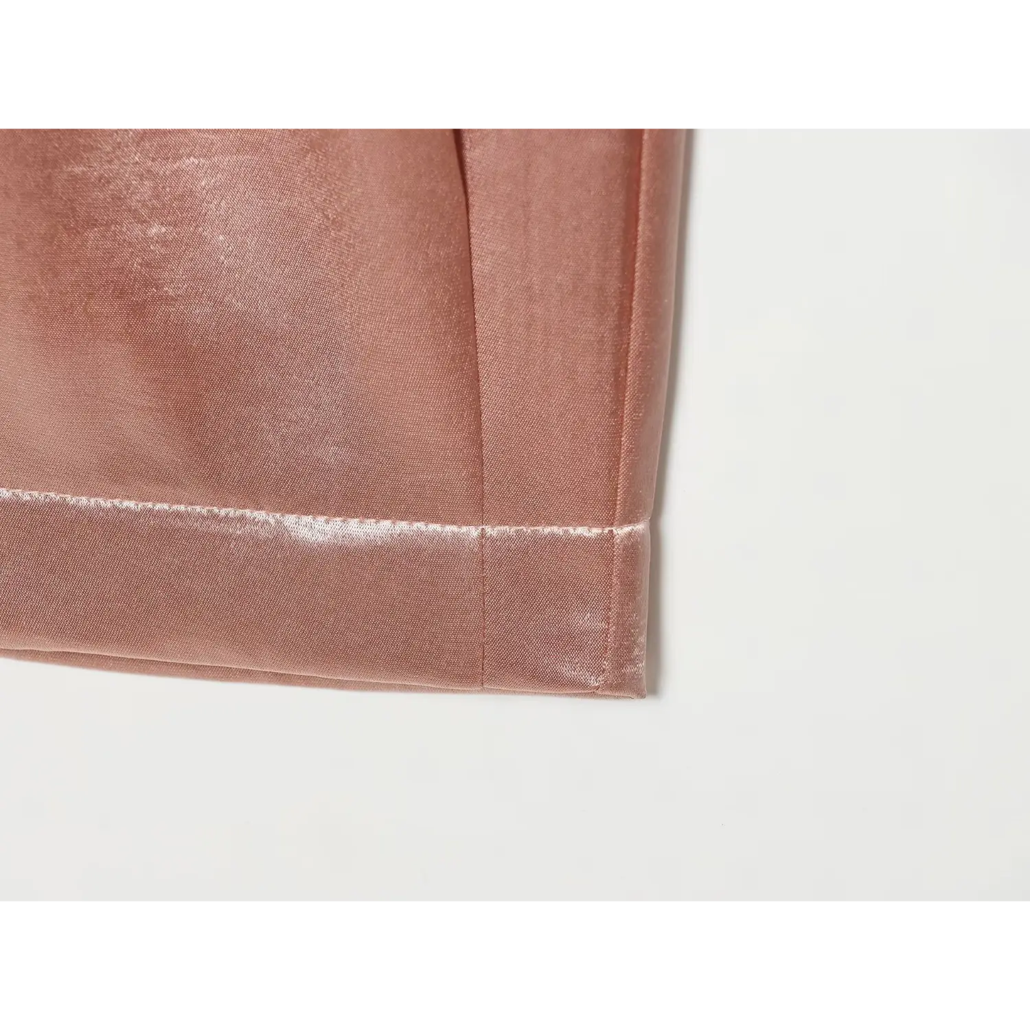 Extreme close‑up fabric texture and cuff seam detail of blush satin cropped trousers