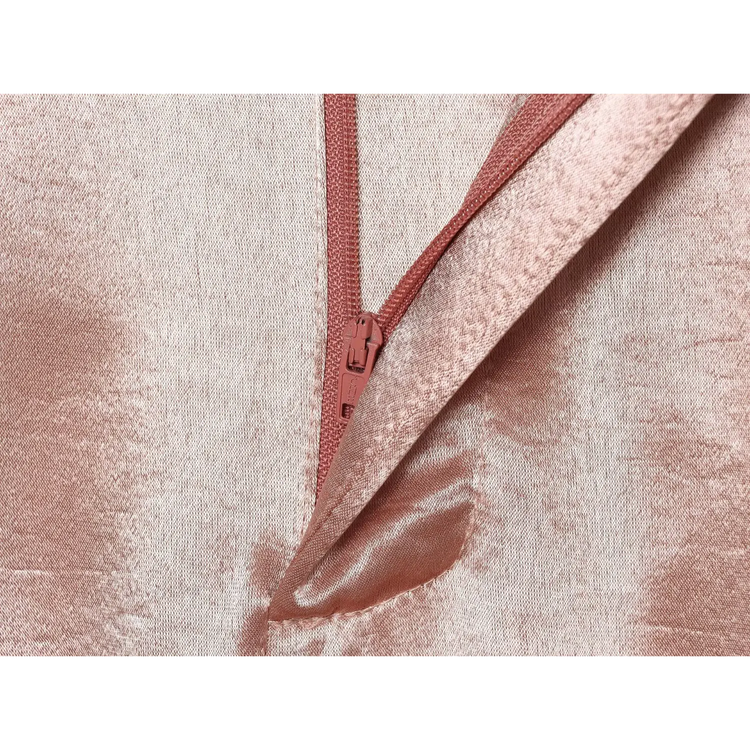 Extreme close‑up side invisible zipper and stitching detail on blush textured satin trousers