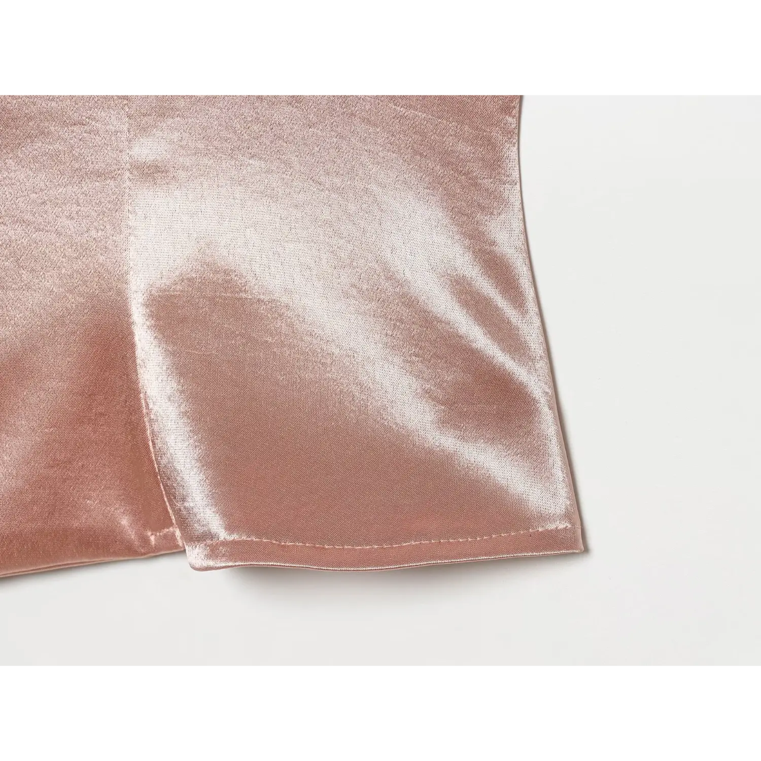 Close‑up bottom hem stitching and textured satin fabric of blush vest