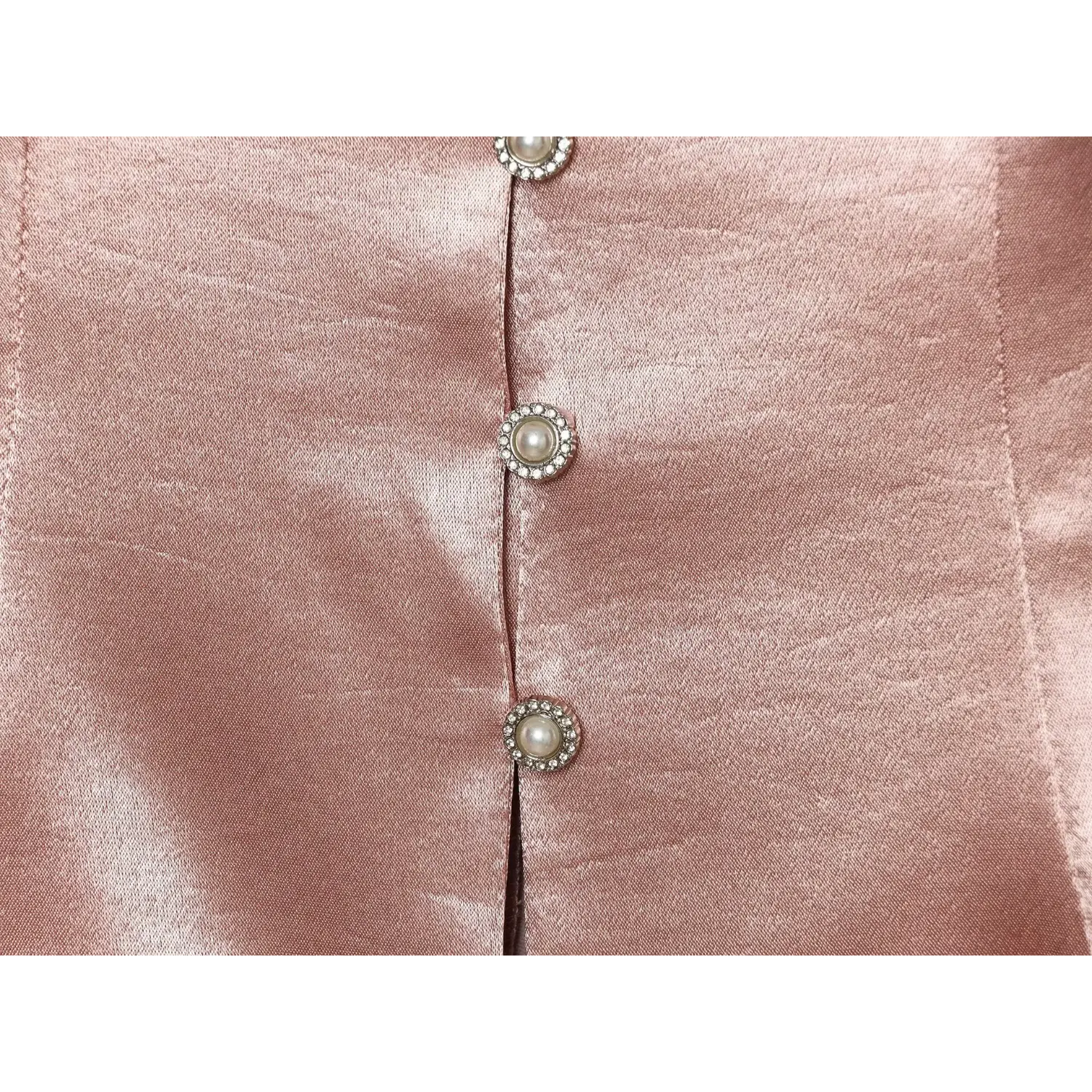 Extreme close‑up decorative pearl rhinestone front buttons on blush satin vest