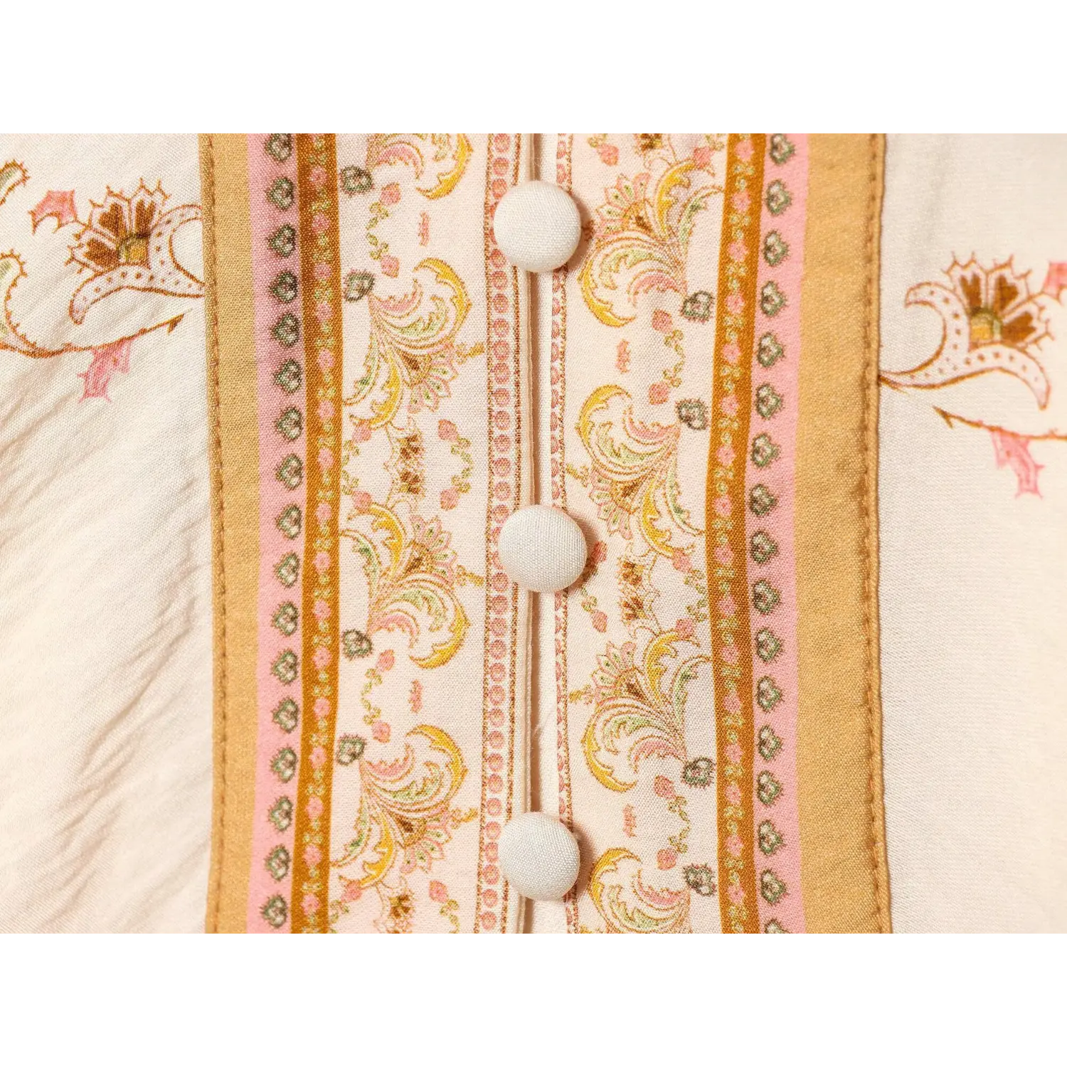 Macro shot of fabric covered buttons and front placket paisley border print