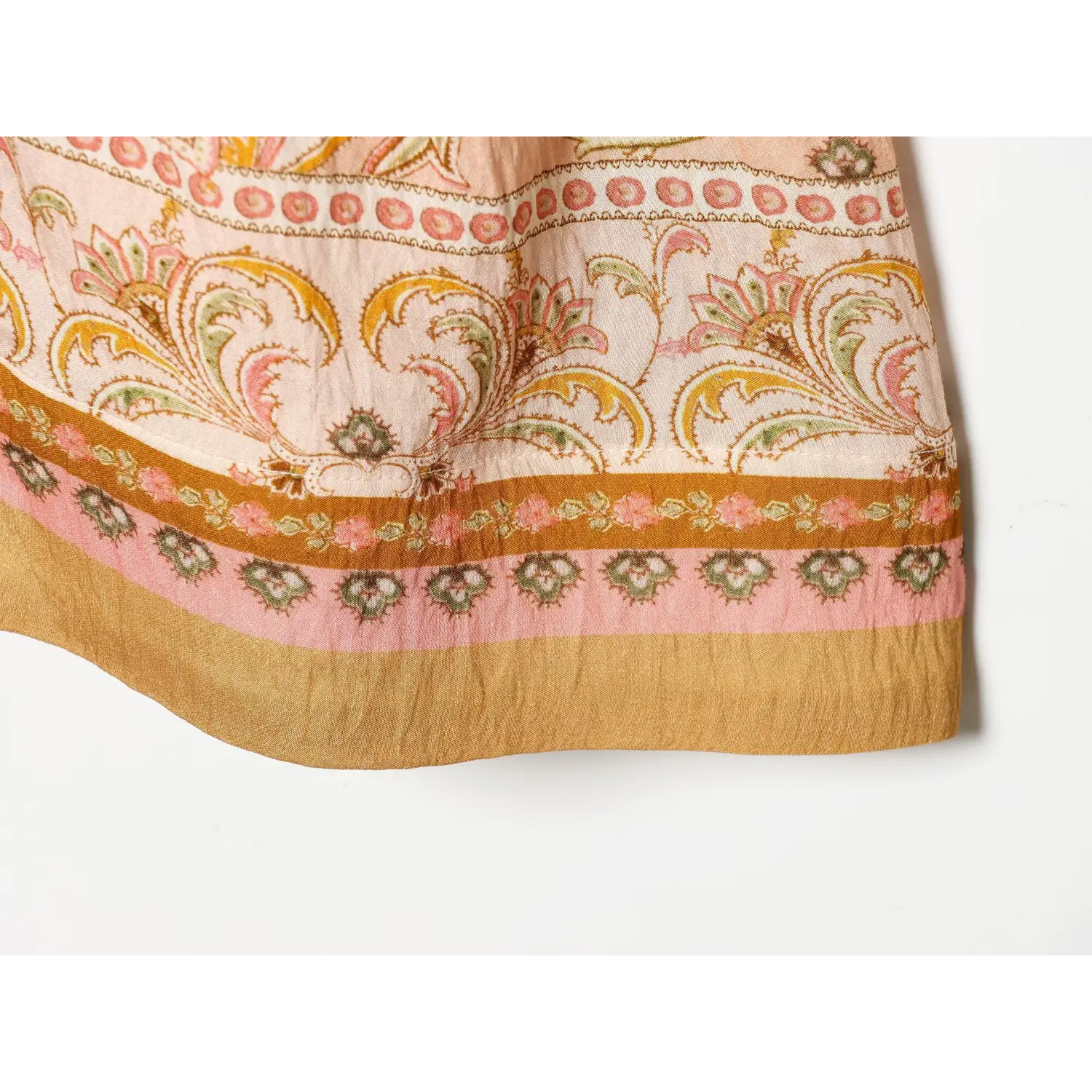 Close‑up of boho paisley mini dress hem, multi‑color border print and crinkled fabric
