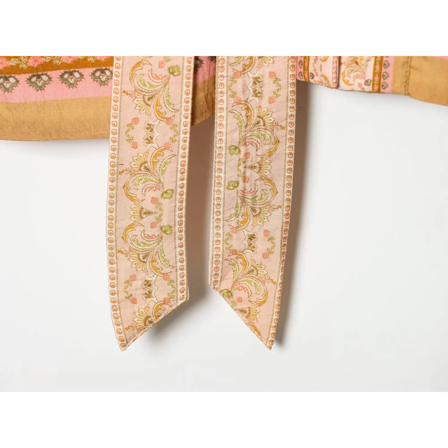 Close‑up of two pointed ends of matching printed fabric tie belt for boho mini dress