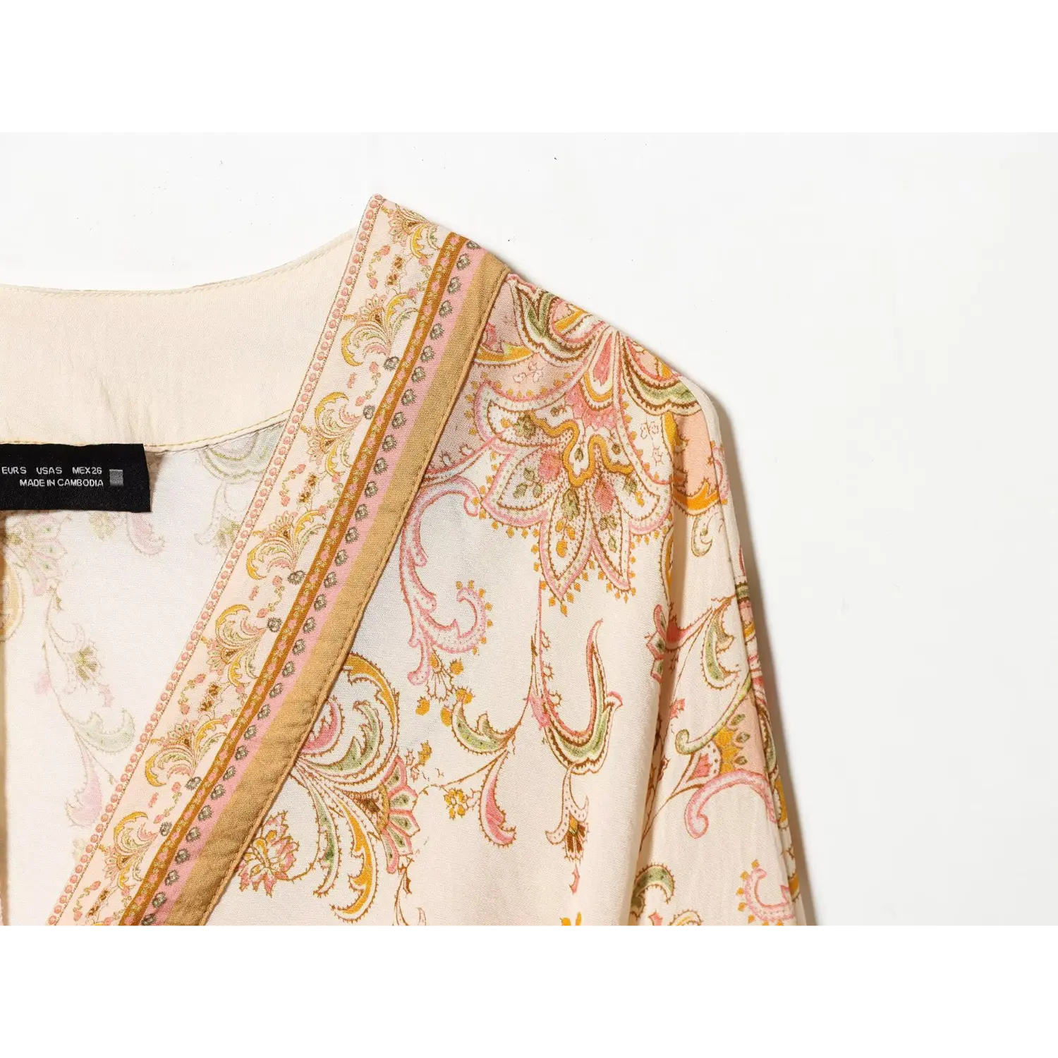 Macro detail of neck trim and vintage paisley floral fabric print