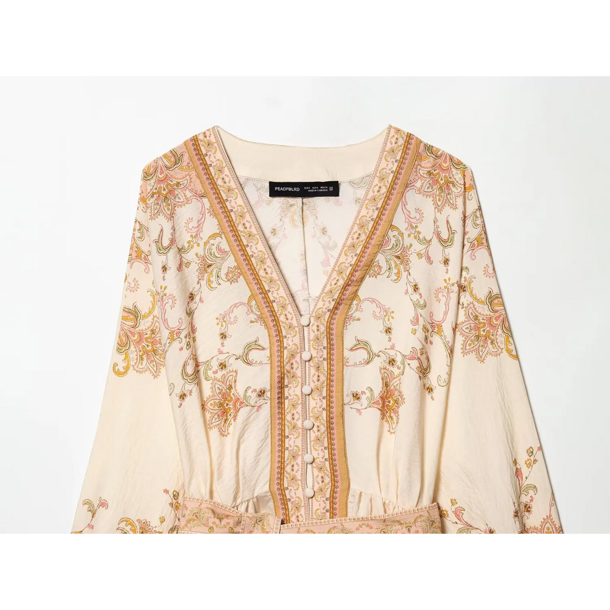 Close‑up of v‑neckline and button placket on boho paisley print mini dress