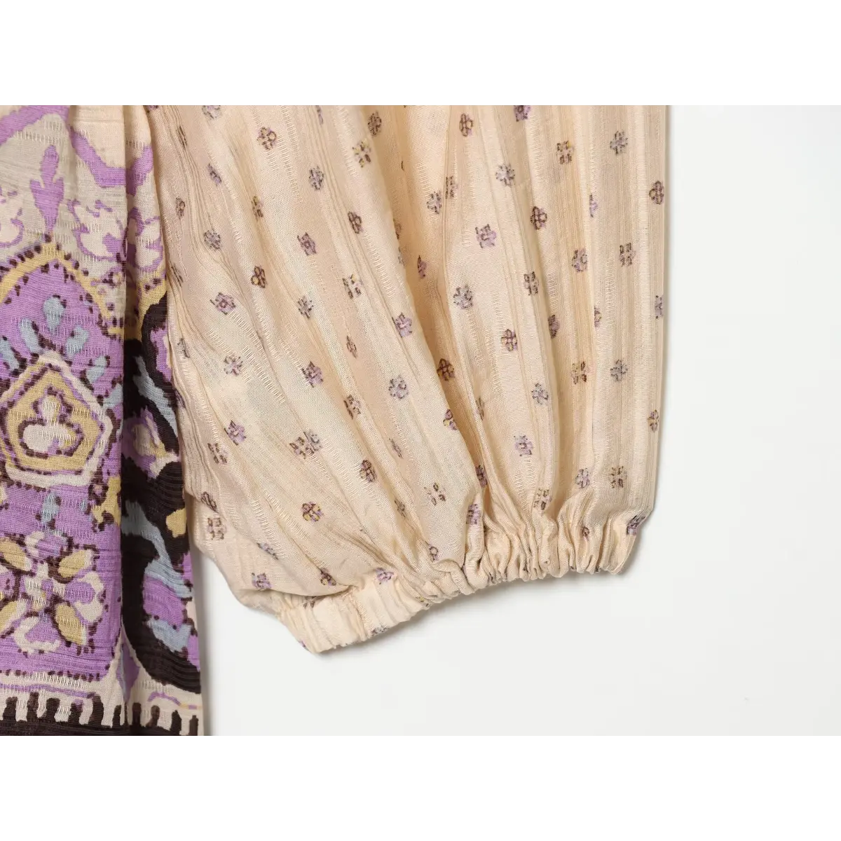 Close-up of the gathered cuff on the balloon sleeve of a boho printed mini dress.