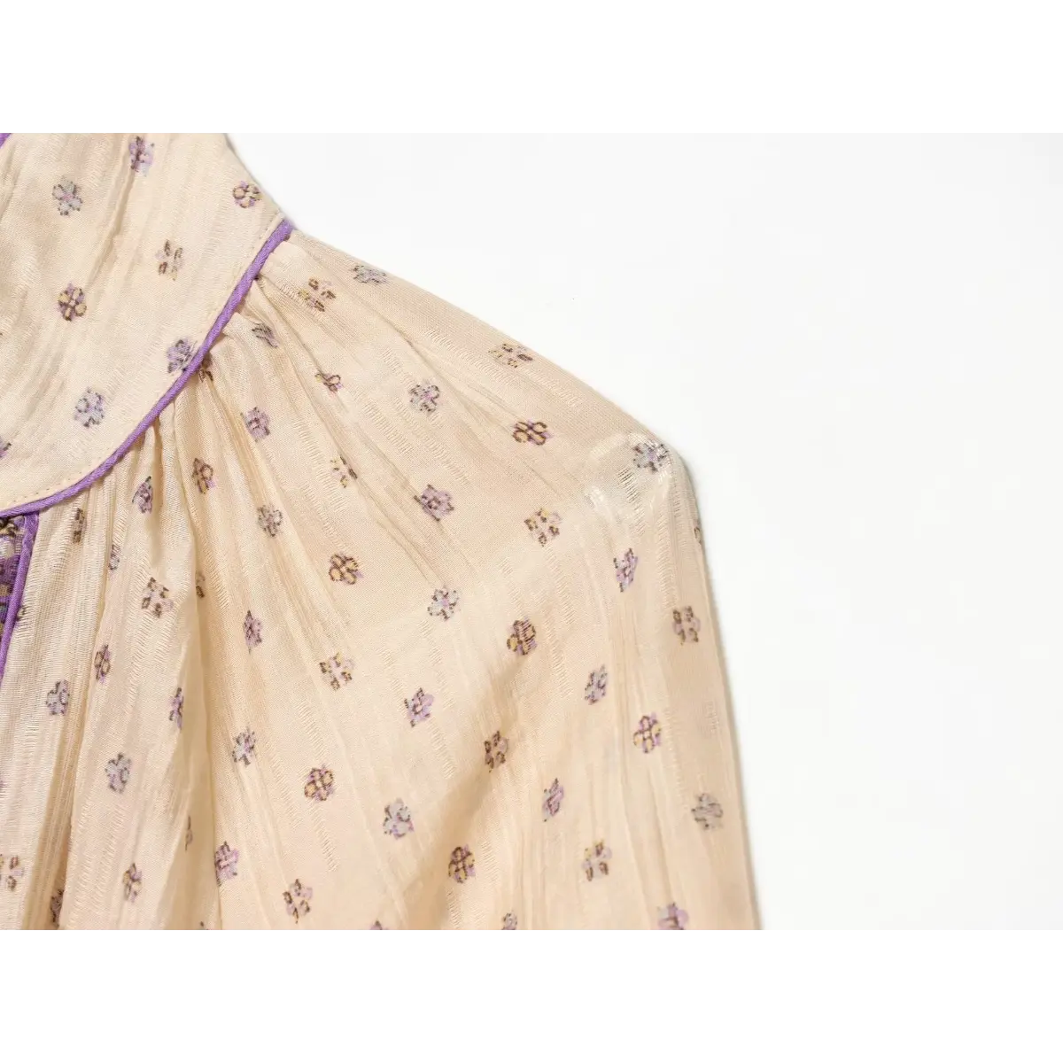 Close-up of the shoulder seam and gathered balloon sleeve on a boho printed mini dress.